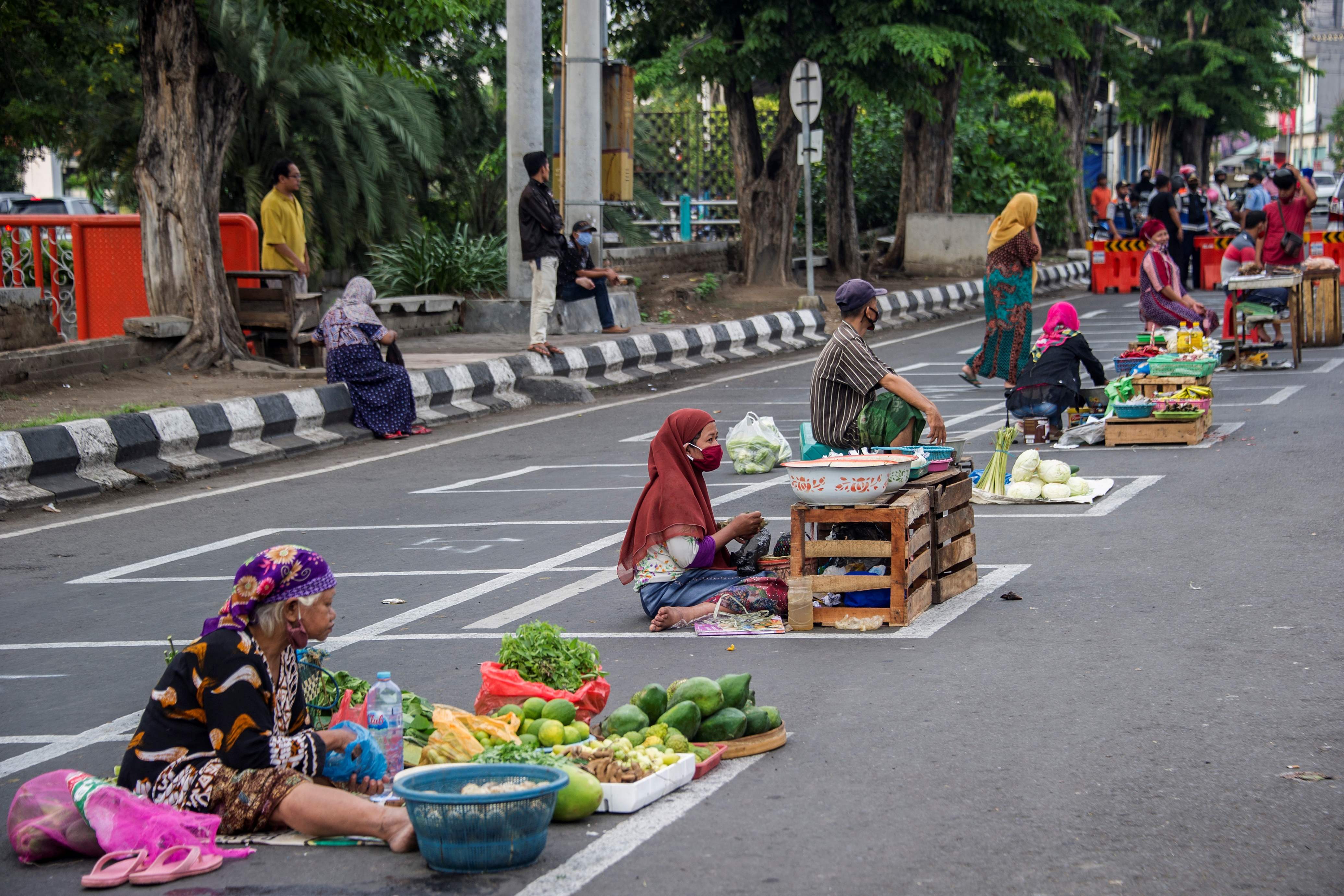 Pedagang menerapkan pembatasan jarak atau physical distancing di Surabaya