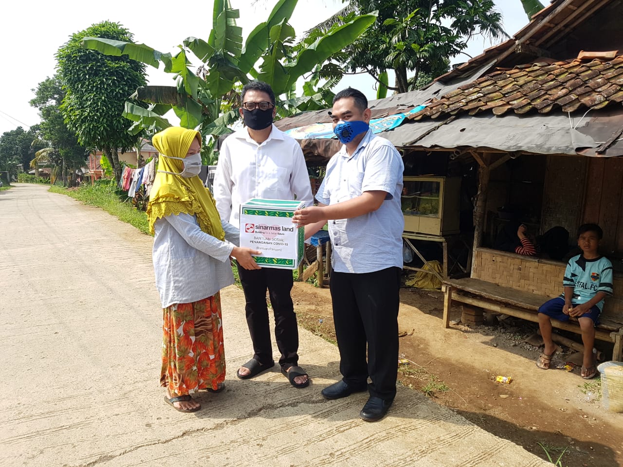 President Office Sinar Mas Land diwakili Ilham Wahyudi (kanan)  enyerahkan bantuan 250 paket bahan di Desa Cibalung, Kecamatan Cijeruk.