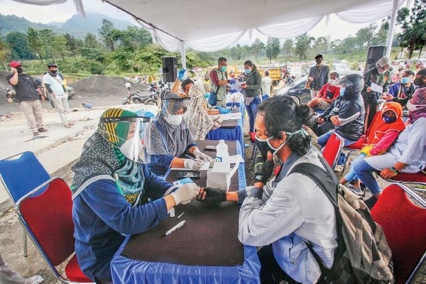 Petugas medis mengambil sampel darah wisatawan saat rapid test di kawasan wisata Puncak, Bogor, Jawa Barat, kemarin.