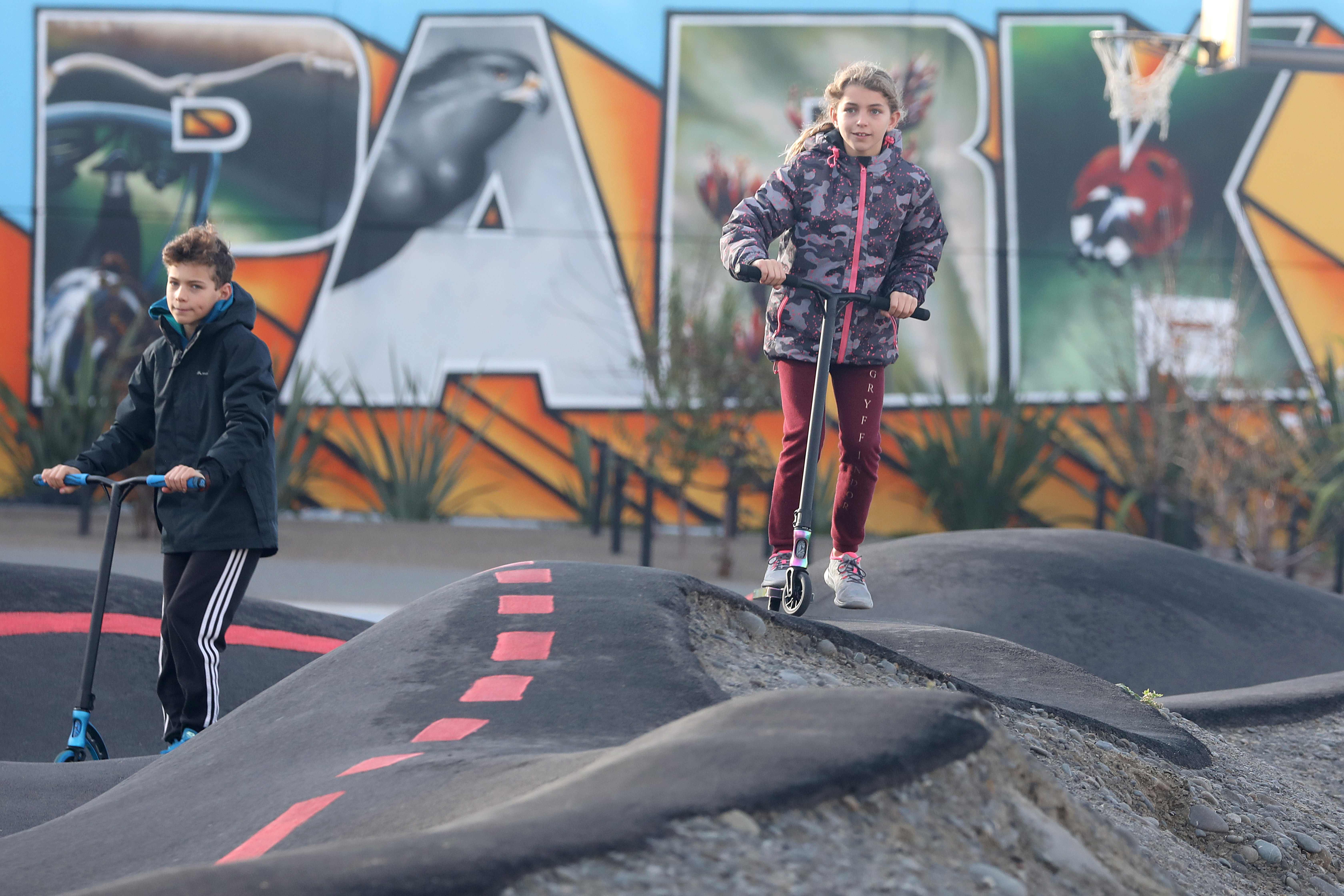 Anak-anak menaiki scooter mereka di taman di  Christchurch 