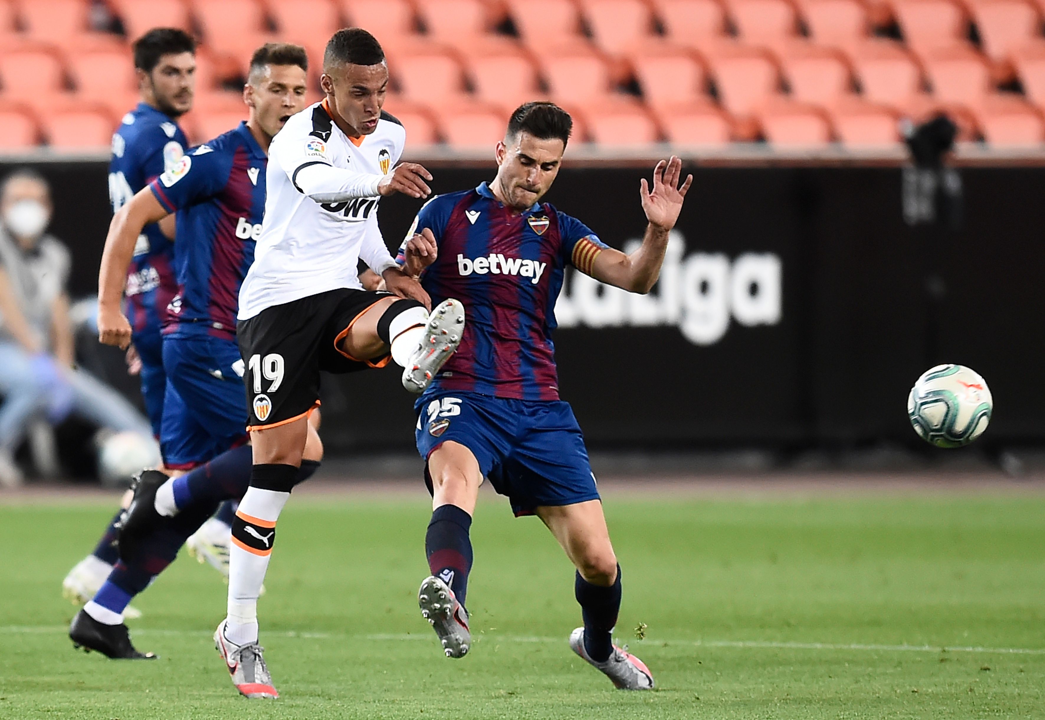 Rodrigo Moreno (kaos putih) berebut bola dengan Sergio Postigo di stadion Mestalla, Valencia (12/6/2020)