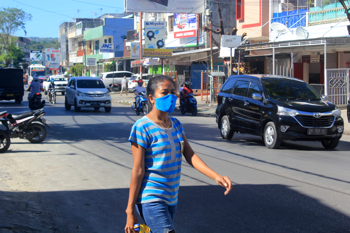  Seorang warga mengenakan masker melintas di ruas Jalan Jenderal Sudirman, Kota Kupang, Nusa Tenggara Timur, Jumat (29/5/2020).