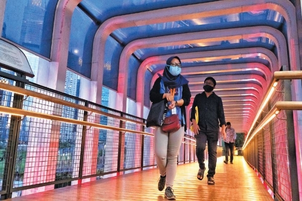 Ilustrasi -- Pekerja berjalan di jembatan penyeberangan orang di Jalan Sudirman, Jakarta, kemarin.