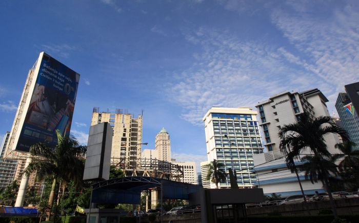 Langit biru mewarnai cuaca cerah diantara gedung-gedung pencakar langit di Jakarta, Minggu (24/01).