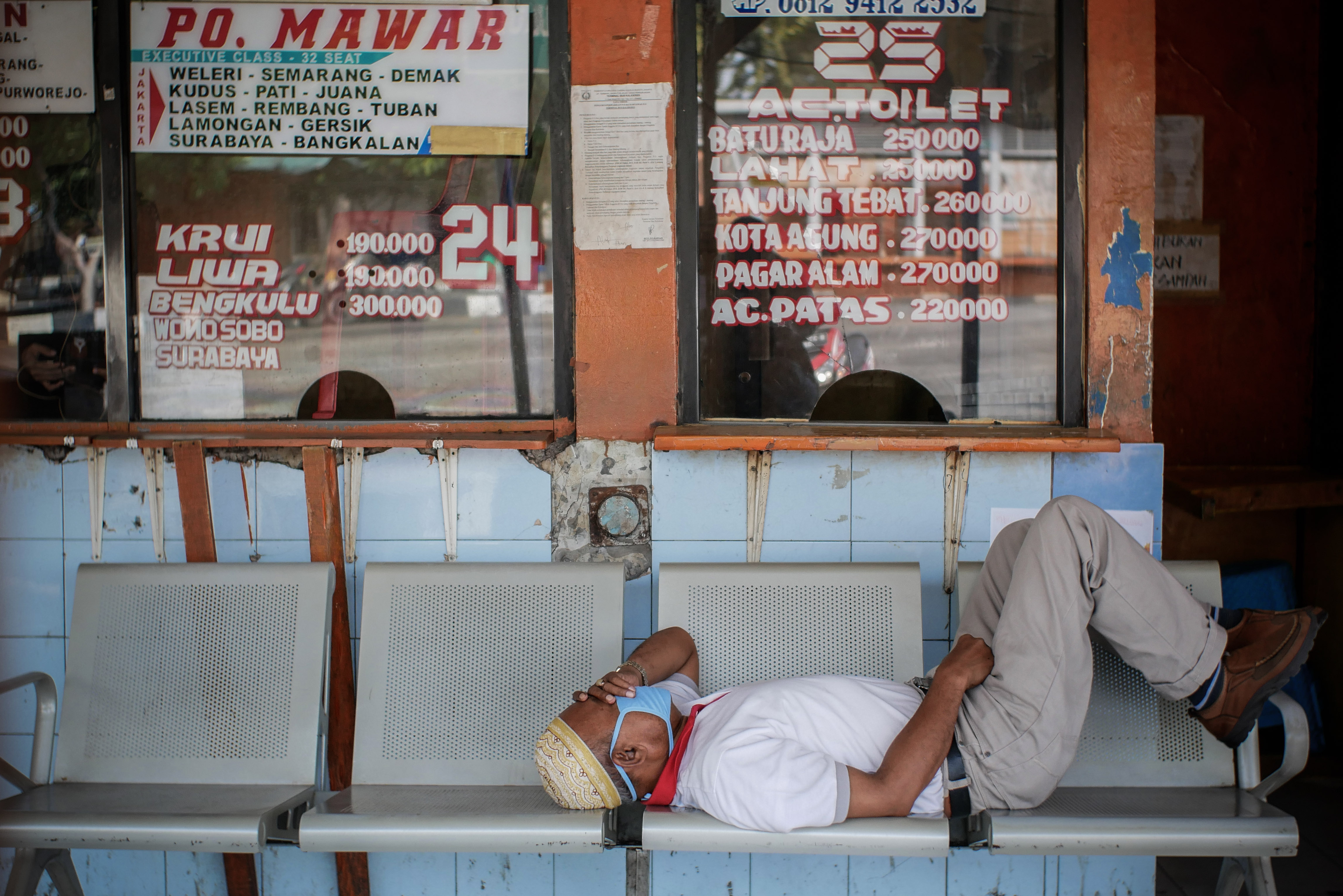 Pekerja Perusahaan Otobus (PO) tidur di depan loket di Terminal Kalideres, Jakarta, Senin (11/5).