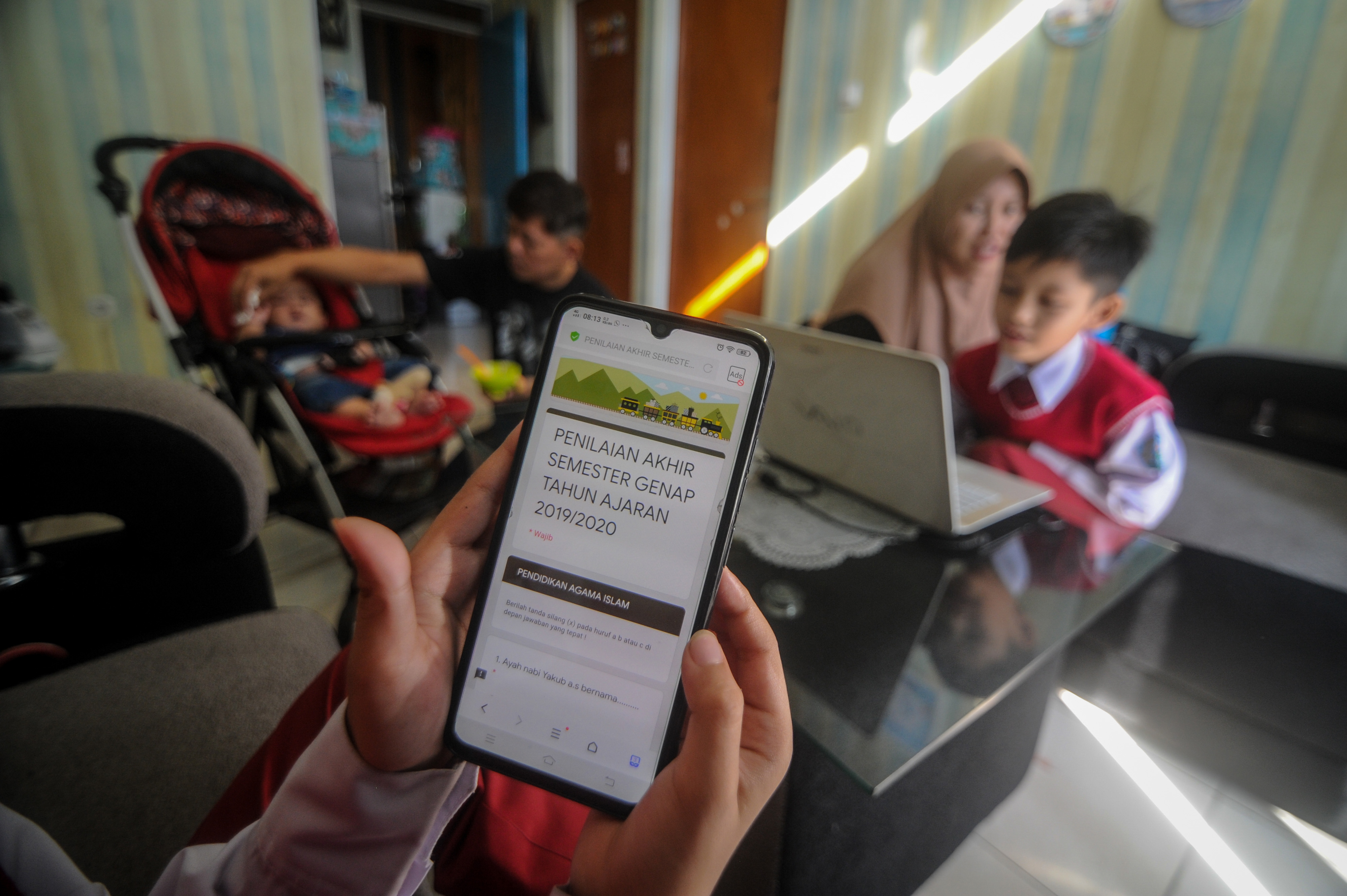 Murid SD mencermati soal ujian akhir yang dilakukan secara daring.