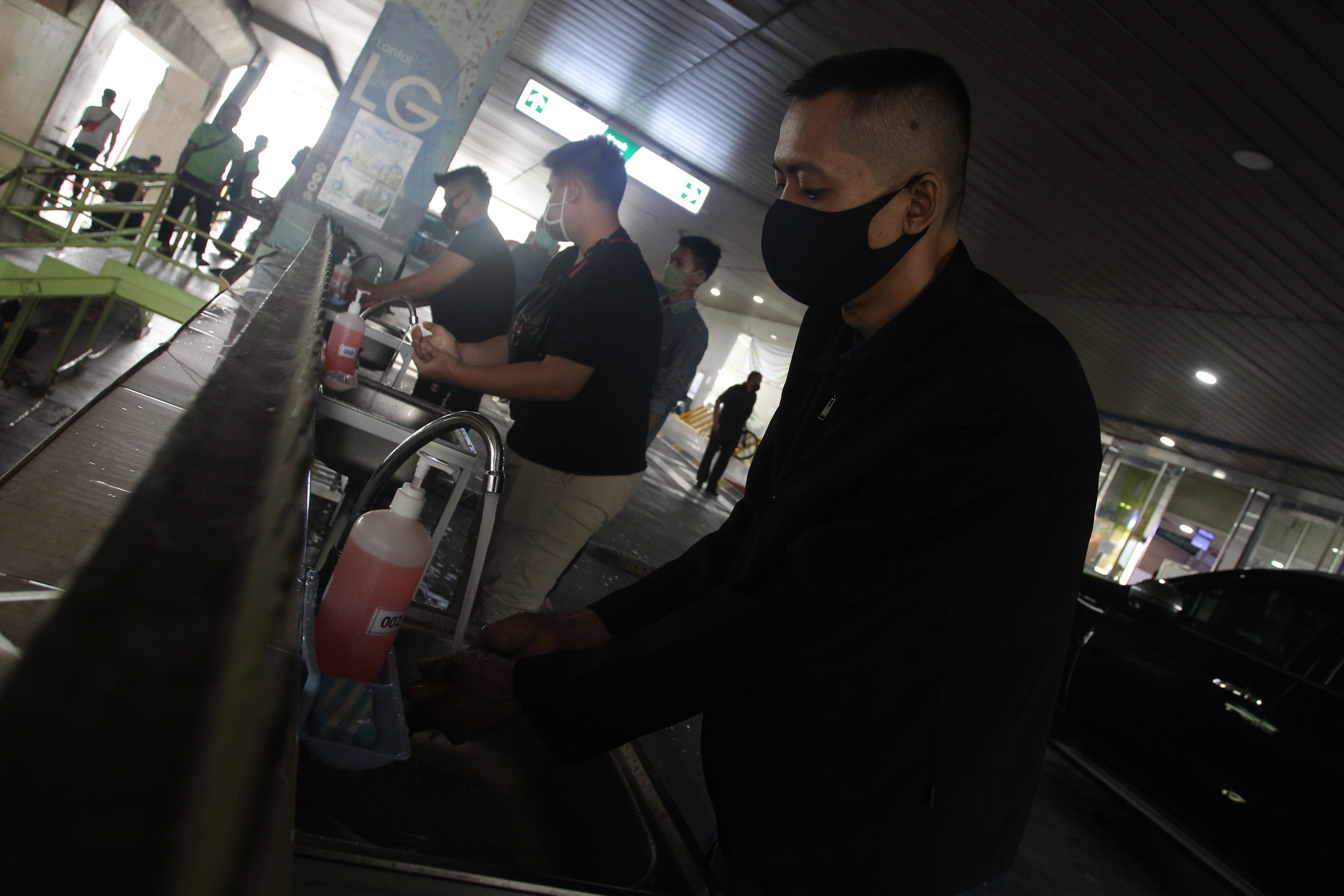 Pengunjung mencuci tangan sebelum memasuki area pusat perbelanjaan Pasar Tanah Abang, Jakarta, Senin (15/6).