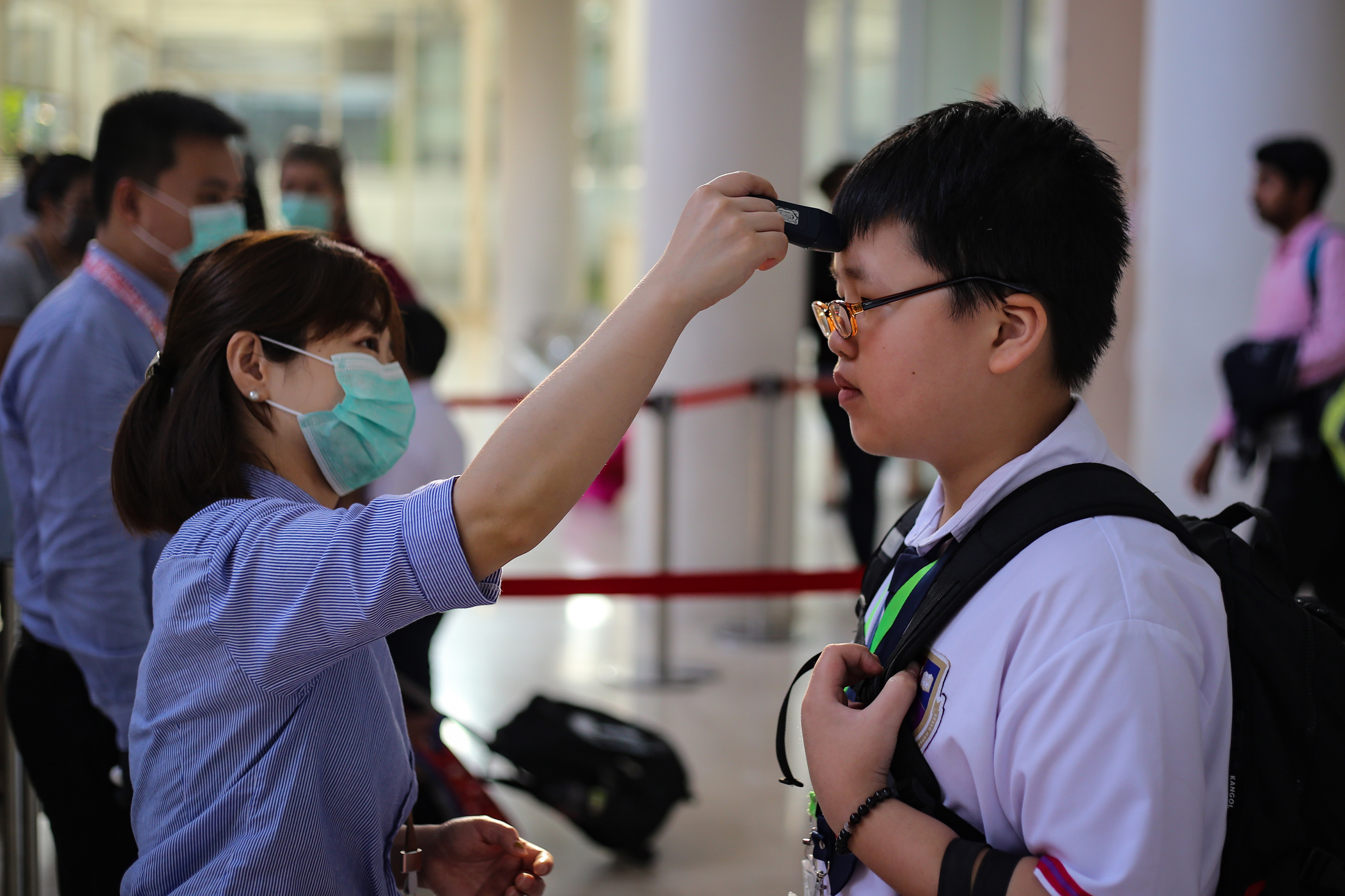 Pengecekan suhu bagi siswa sebelum masuk kelas