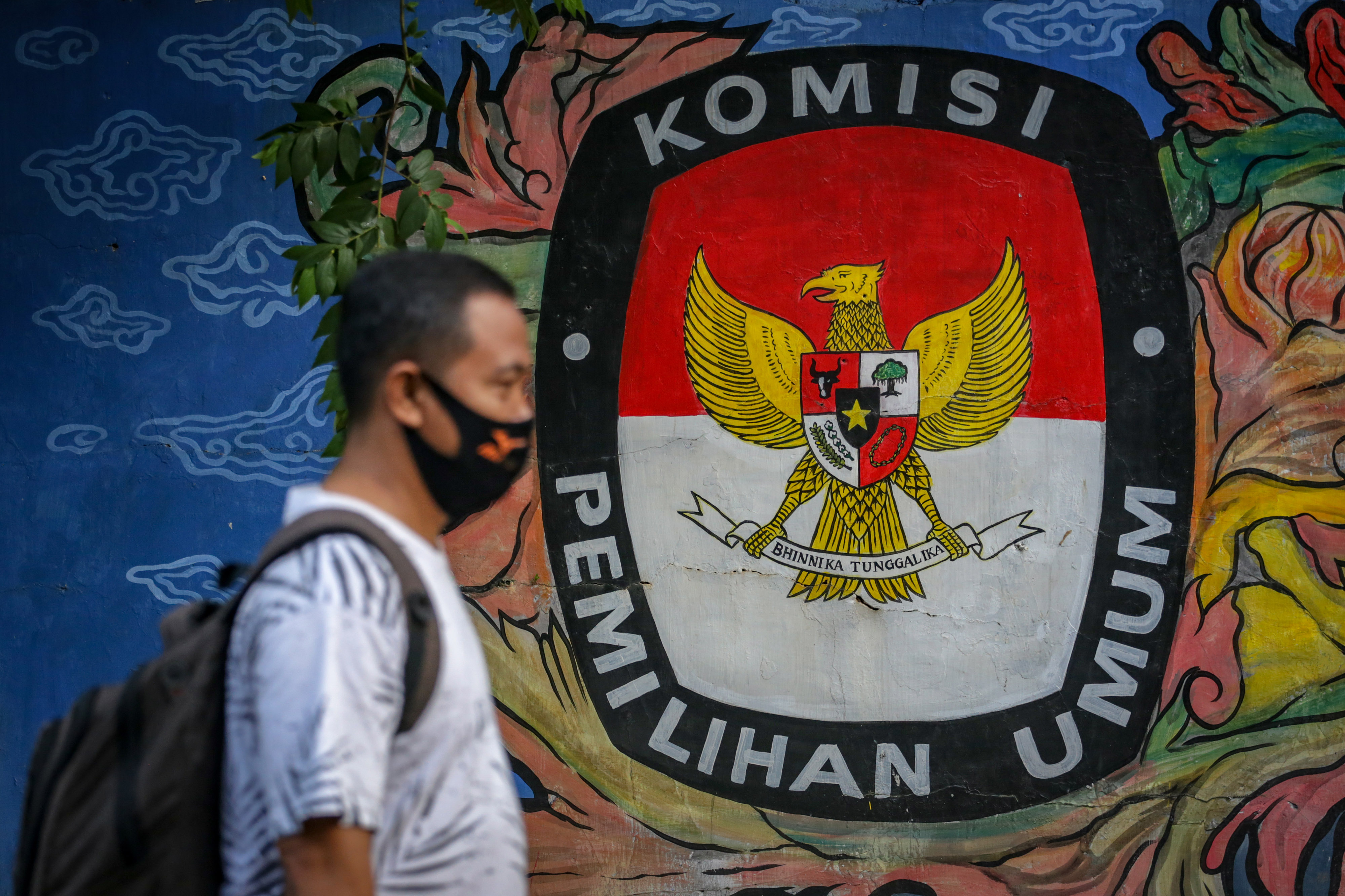Warga melintas di depan mural bertema pemilihan umum di kawasan Pasar Anyar, Kota Tangerang, Banten, Kamis (7/5). 