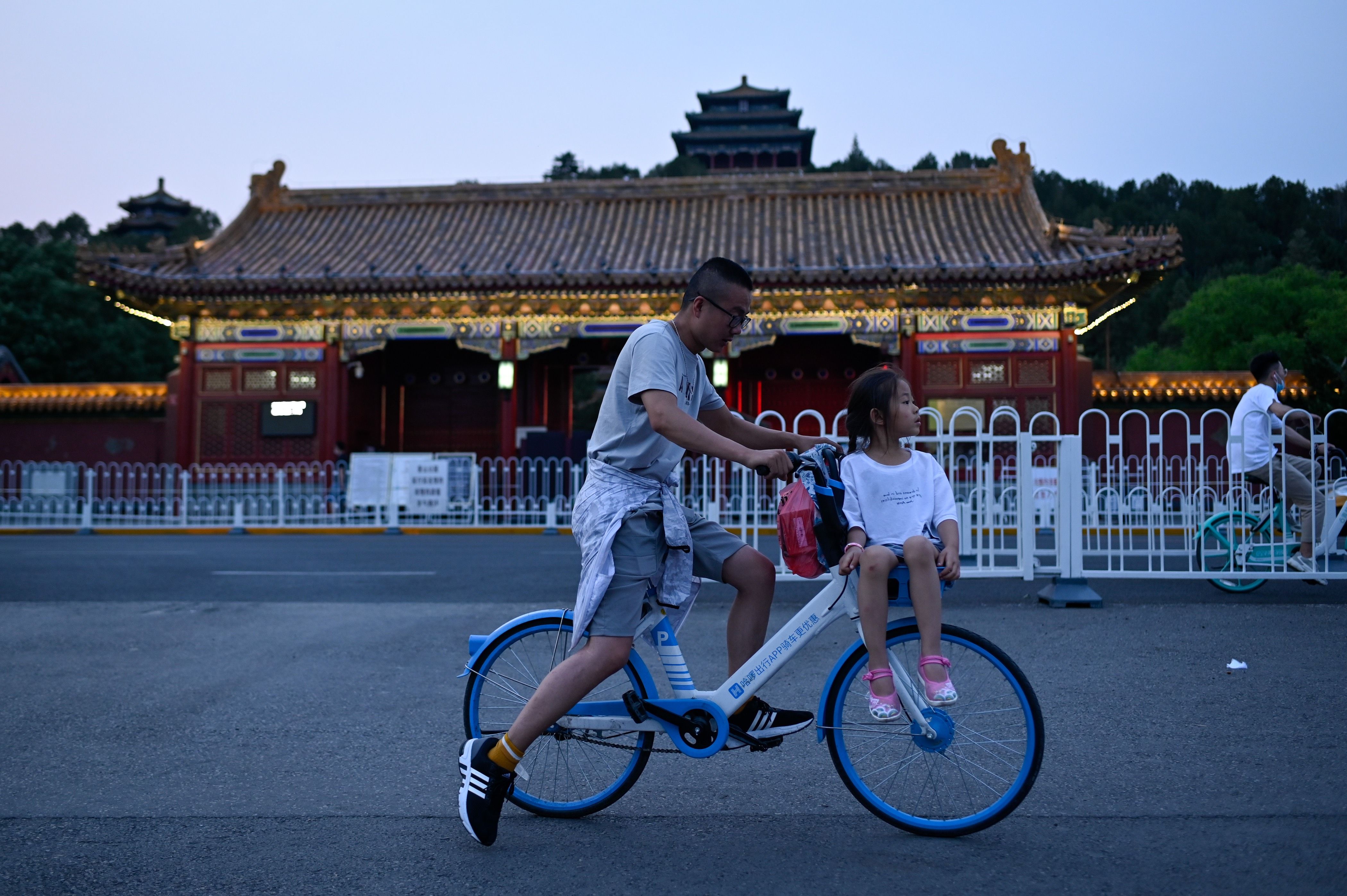 Pria dan anak perempuan yang duduk di depan sepedanya di Beijing (6/6/2020)