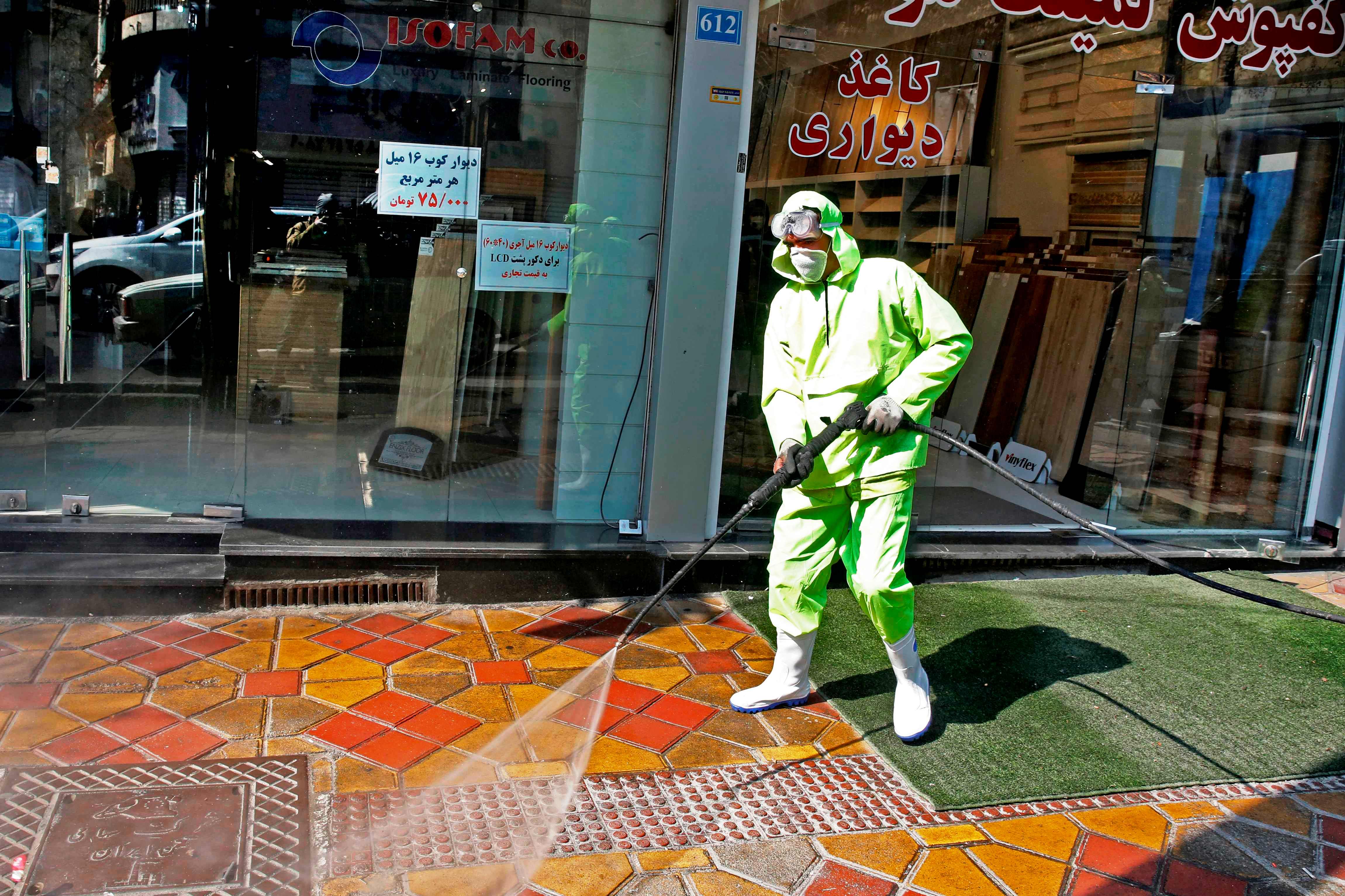 Seorang petugas melakukan penyemprotan disinfektan di Teheran.