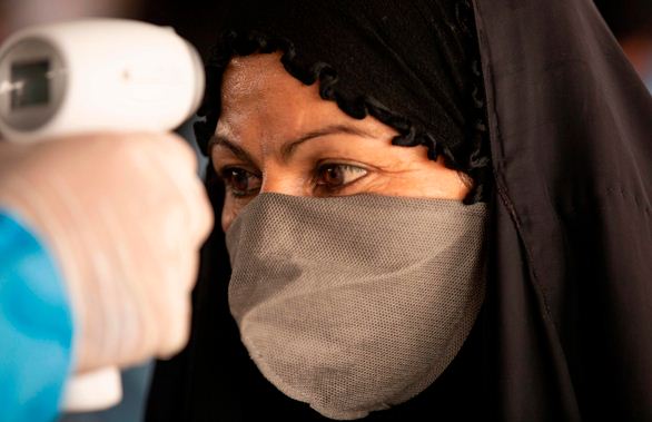 Seorang perempuan di Iran harus menjalani pemeriksaan suhu tubuh sebagai protokol menghadapi covid-19 di negeri itu. 