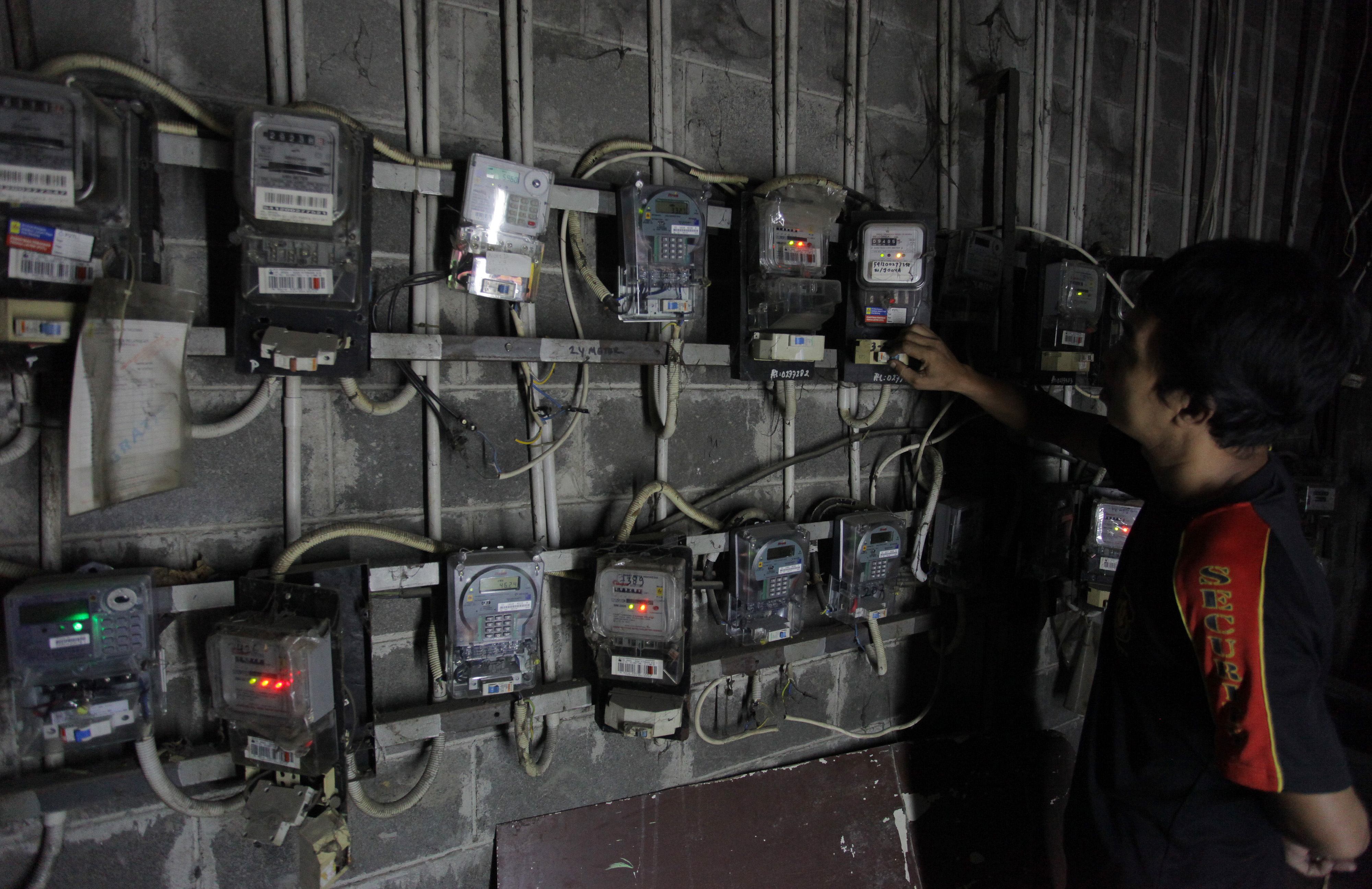 Warga petamburan, Jakarta Pusat mengecek meteran listrik di area tempat tinggalnya