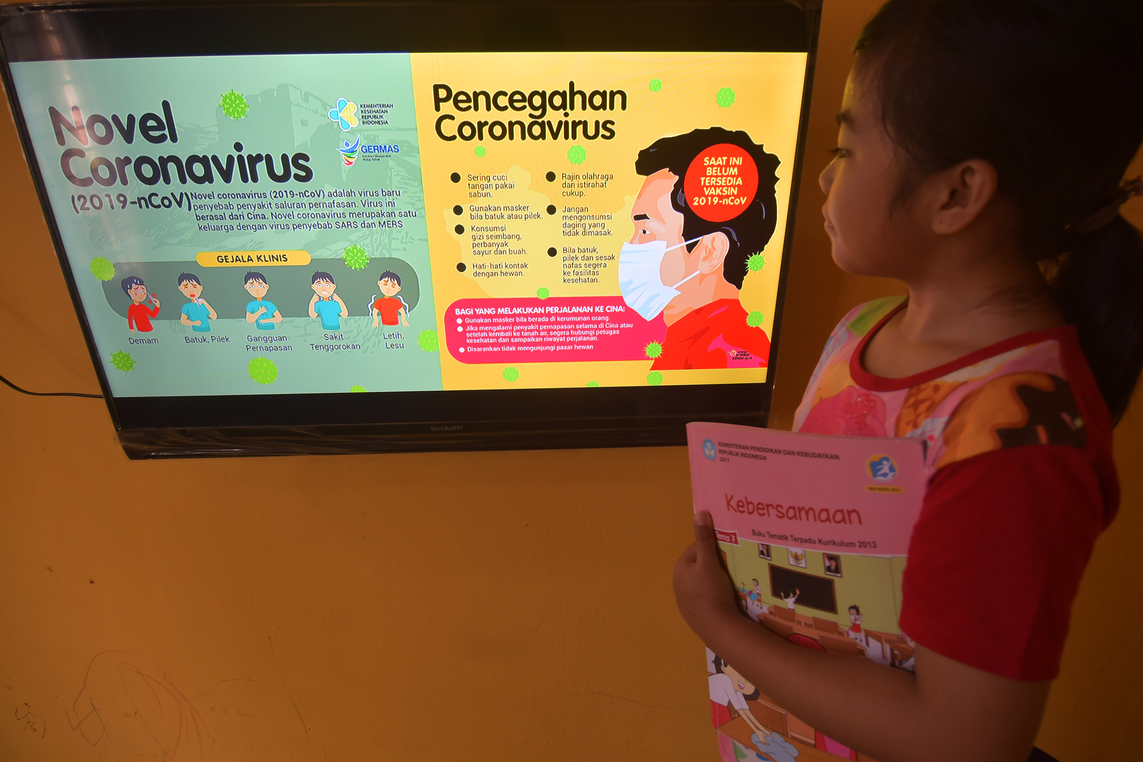 Seorang siswa di Palu, Sulawesi Tengah, menyaksikan tayangan informasi terkait covid-19.