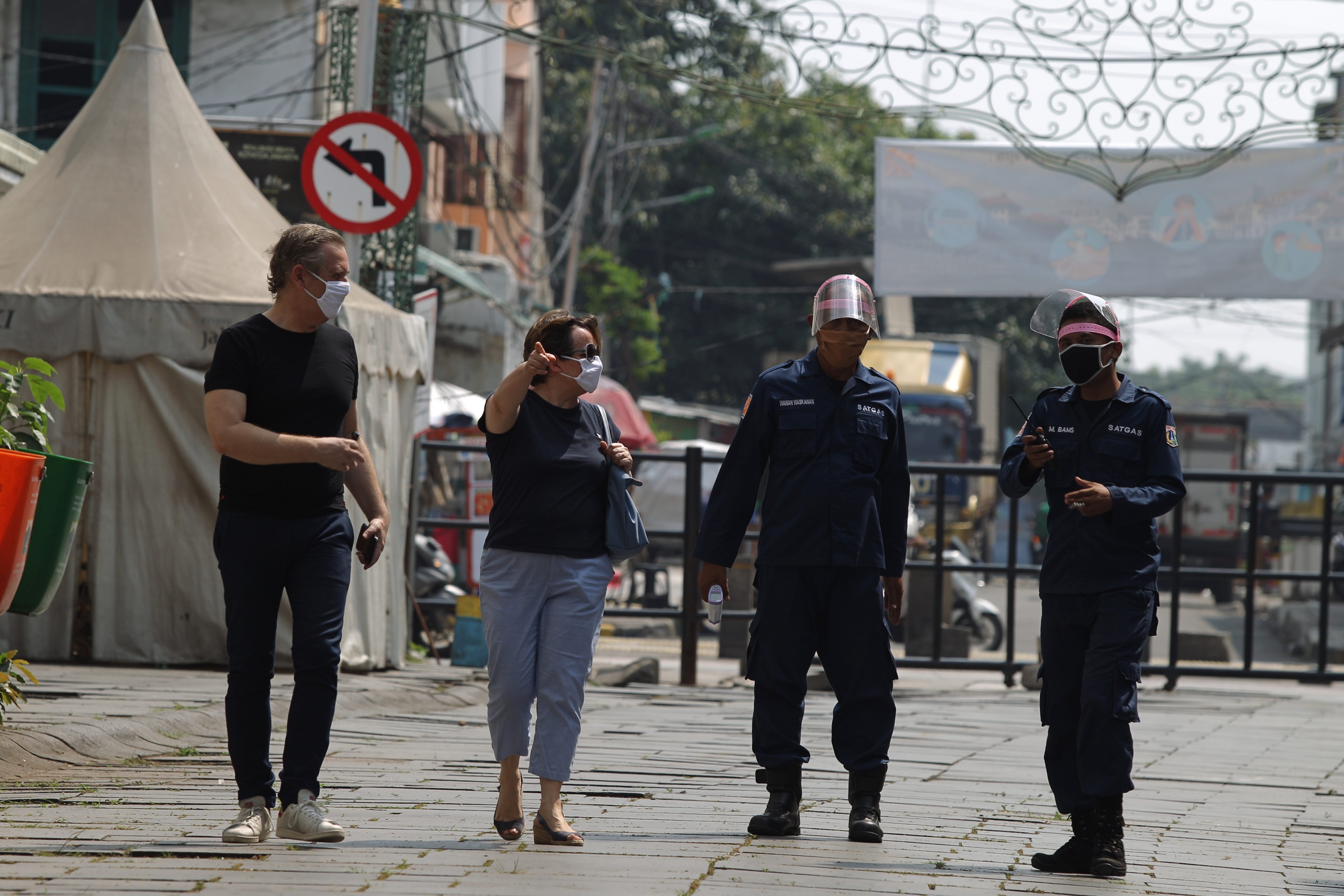 Turis bertanya kepada petugas keamanan di taman Fatahilah kawasan wisata Kota Tua, Jakarta Barat, Jakarta, Sabtu (13/6). 