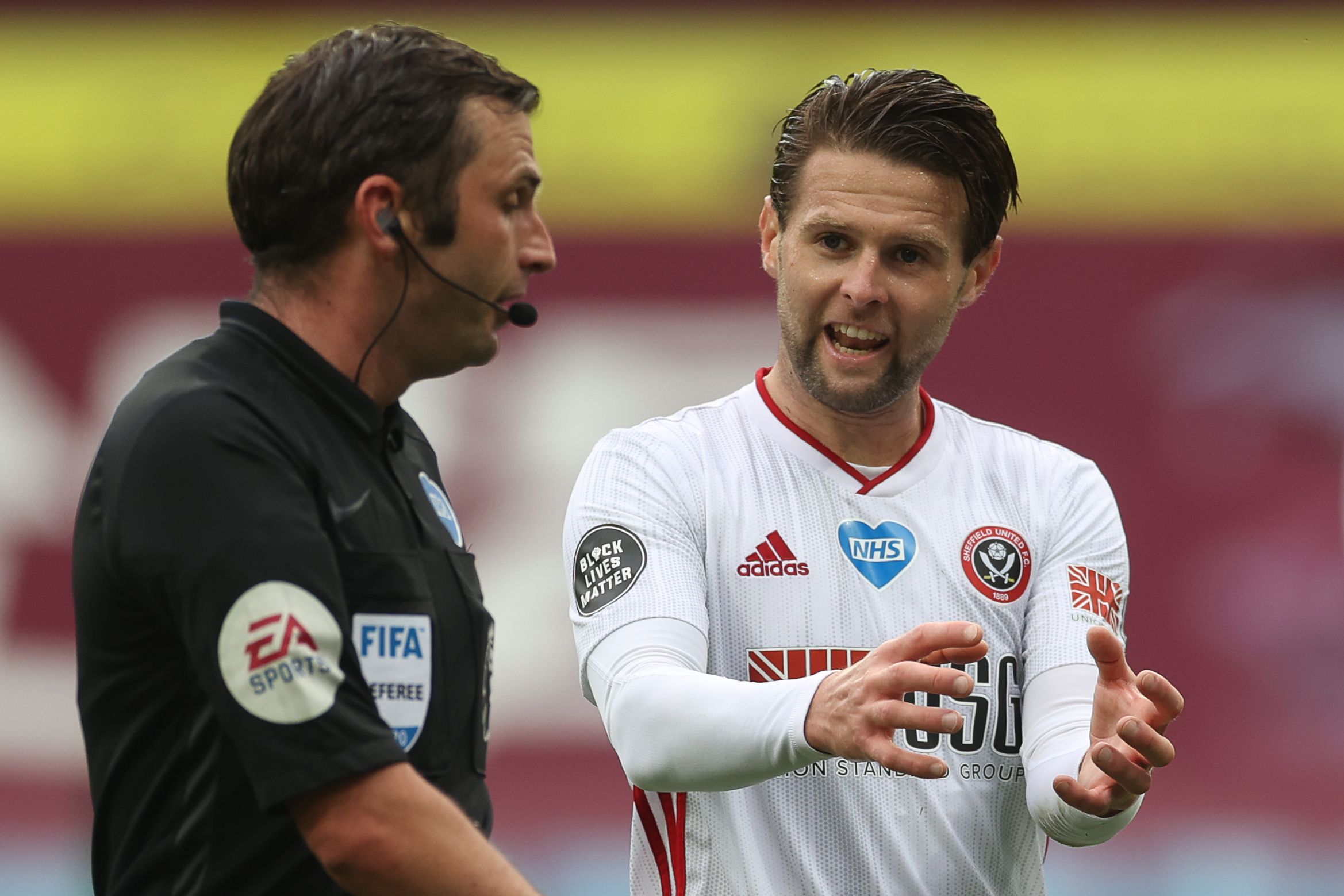 Oliver Norwood (kanan) berbicara dengan wasit Inggris Michael Oliver.