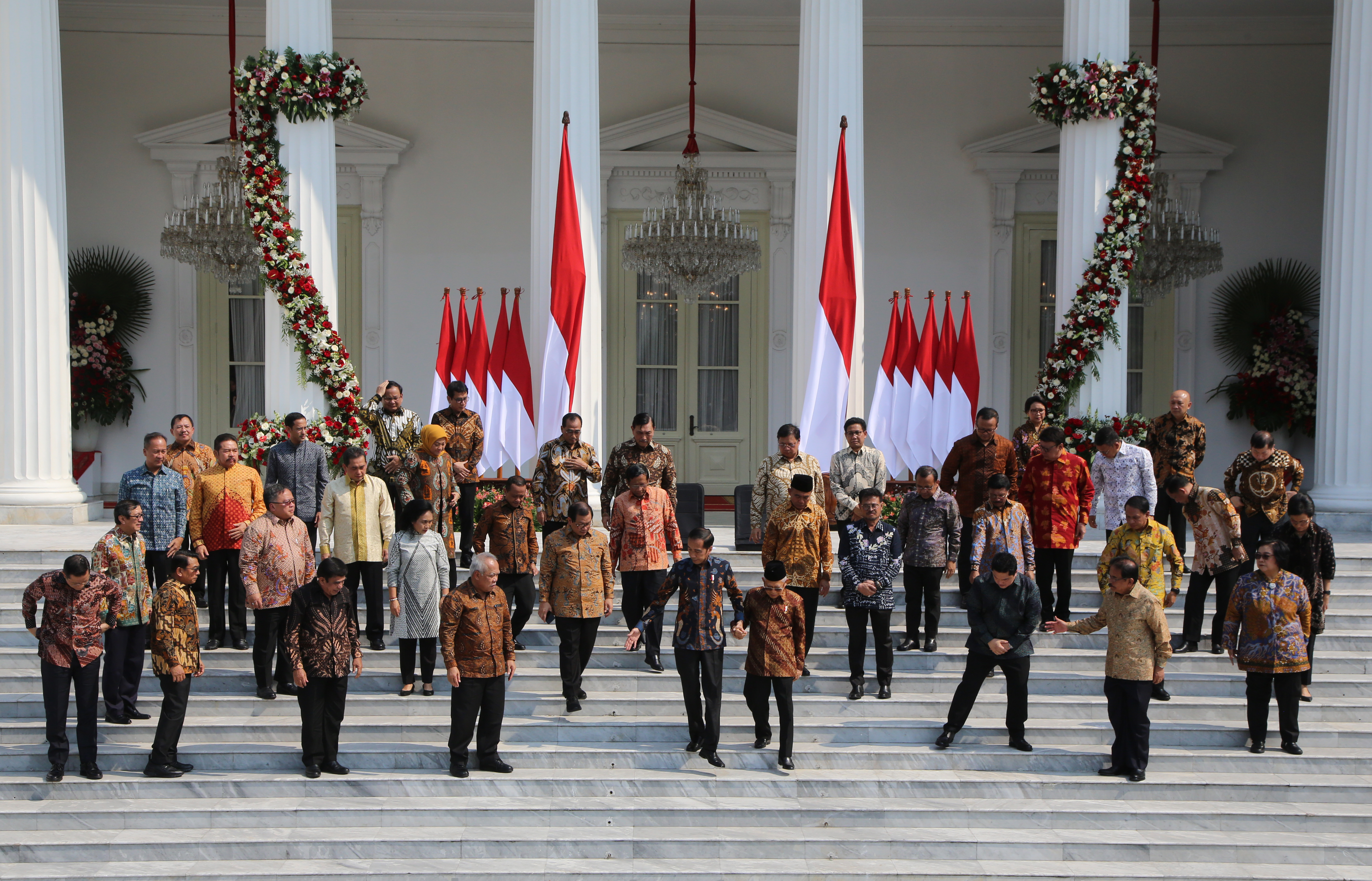 Presiden Joko Widodo menggandeng Wapres Ma'ruf Amin (tengah) saat foto bersama anggota kabinet di Istana Merdeka, Jakarta, Rabu (23/10). 