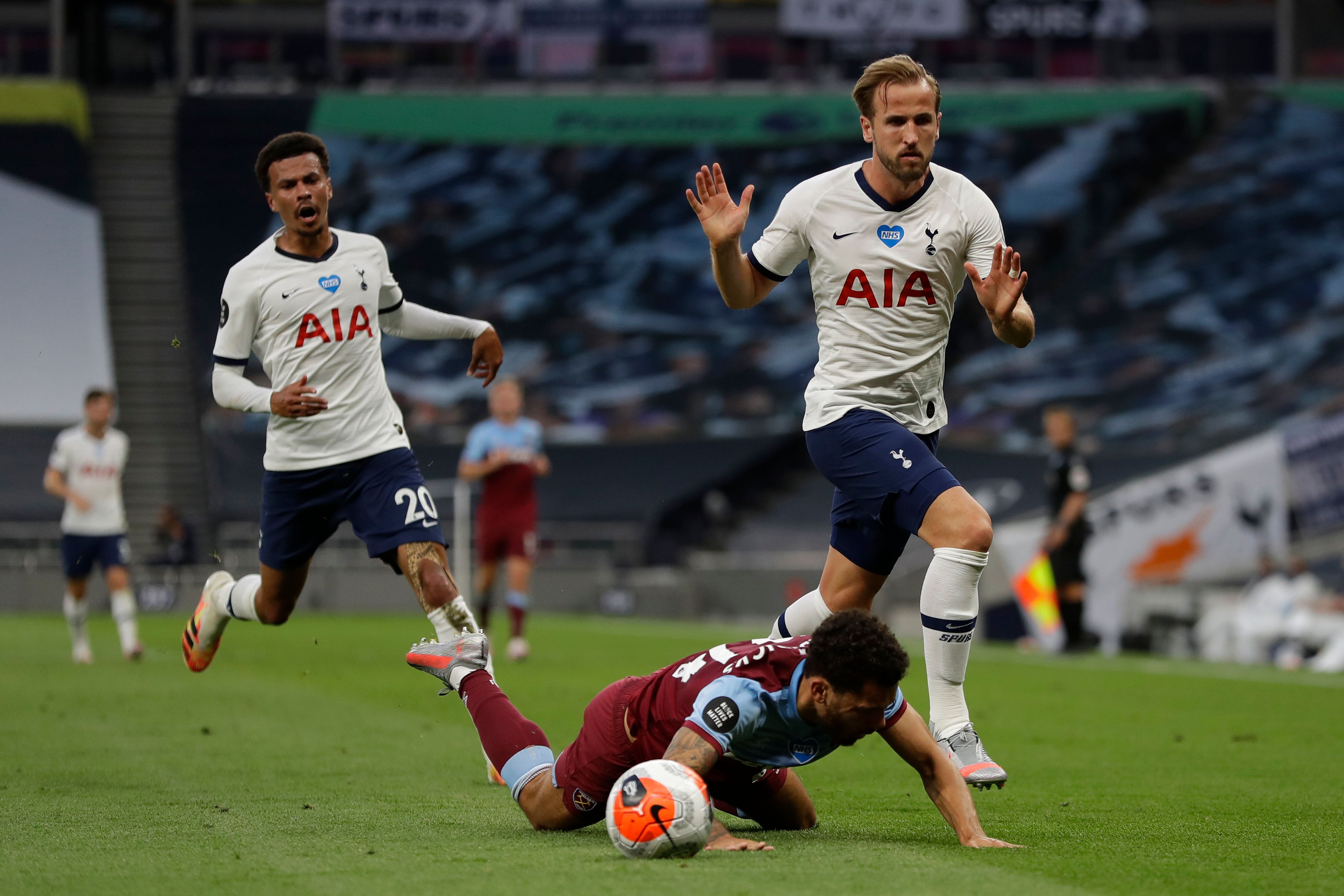 Striker Tottenham Hotspur Harry Kane (kanan) berusaha merebut bola dari pemain West Ham United yang terjatuh.