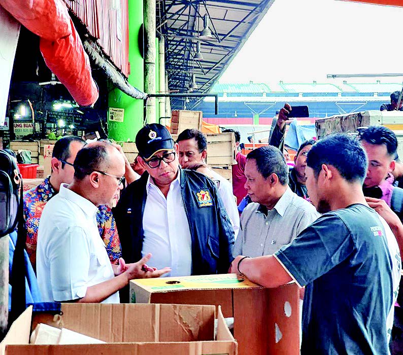 Juan Permata Adoe (jaket hitam) ketika berbincang dengan pedagang buah-buahan di Pasar Induk Kramat Jati, Jakarta Timur, kemarin.