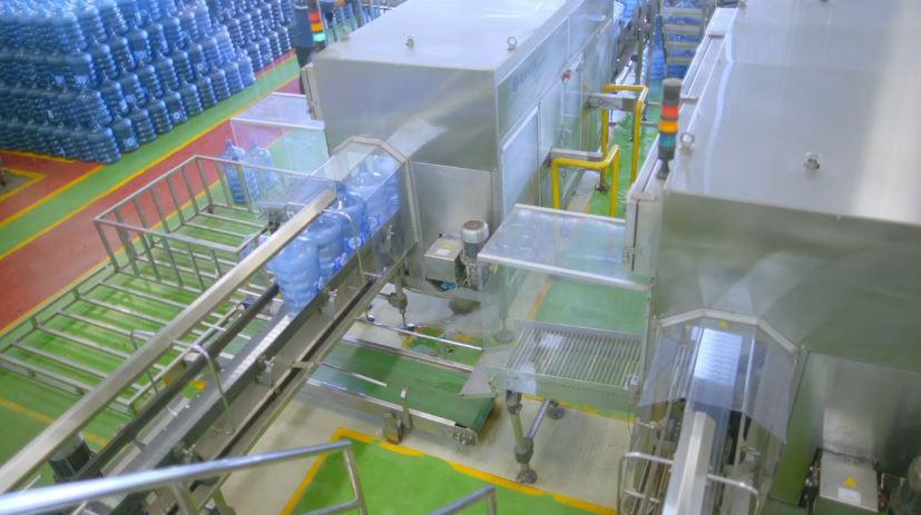 Proses mengemas AMDK galon guna ulang