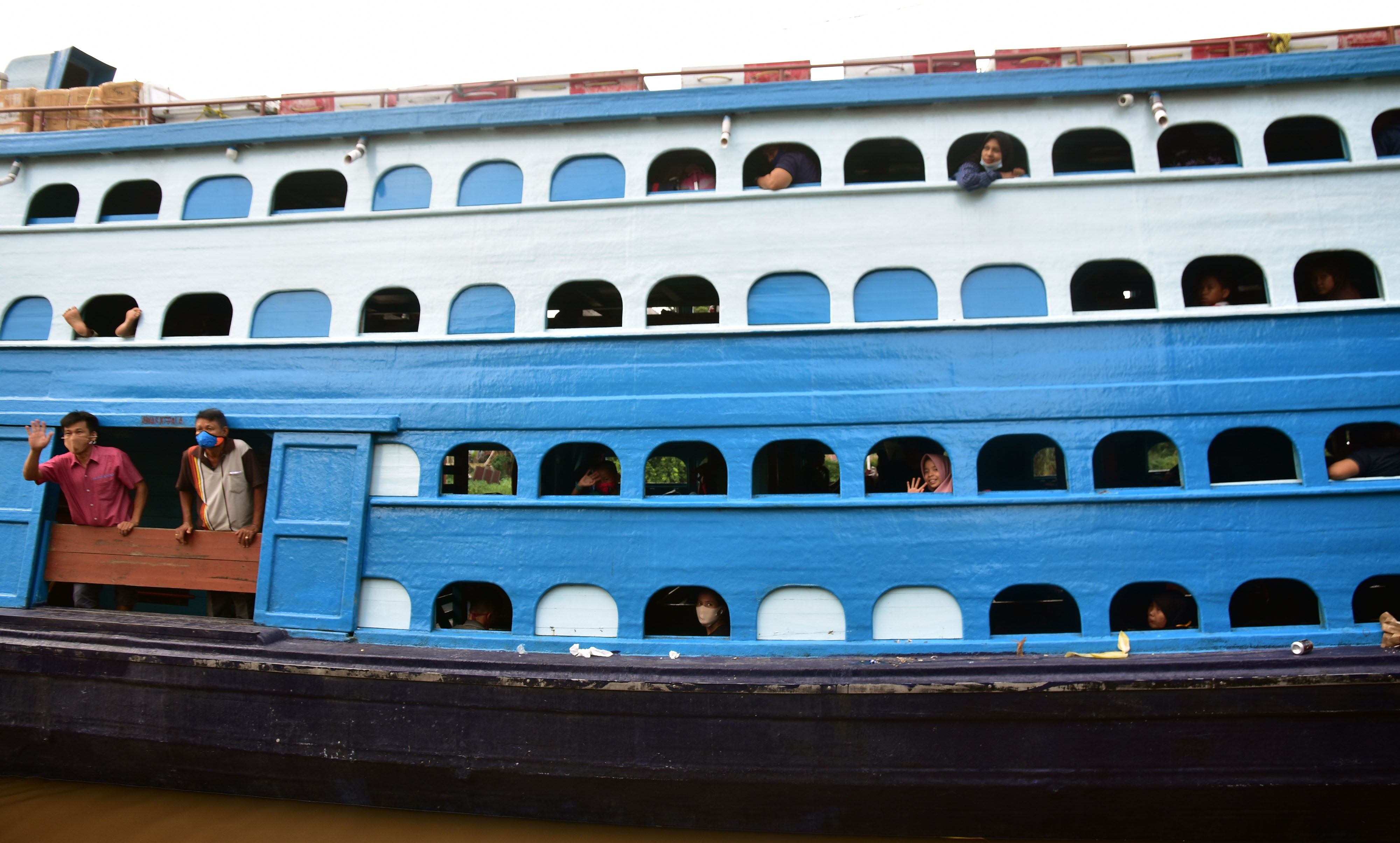 Sejumlah penumpang mengenakan masker saat menaiki kapal kayu Jelatik di Pelabuhan Sungai Duku, Kota Pekanbaru, Riau, Kamis (11/6/2020). 