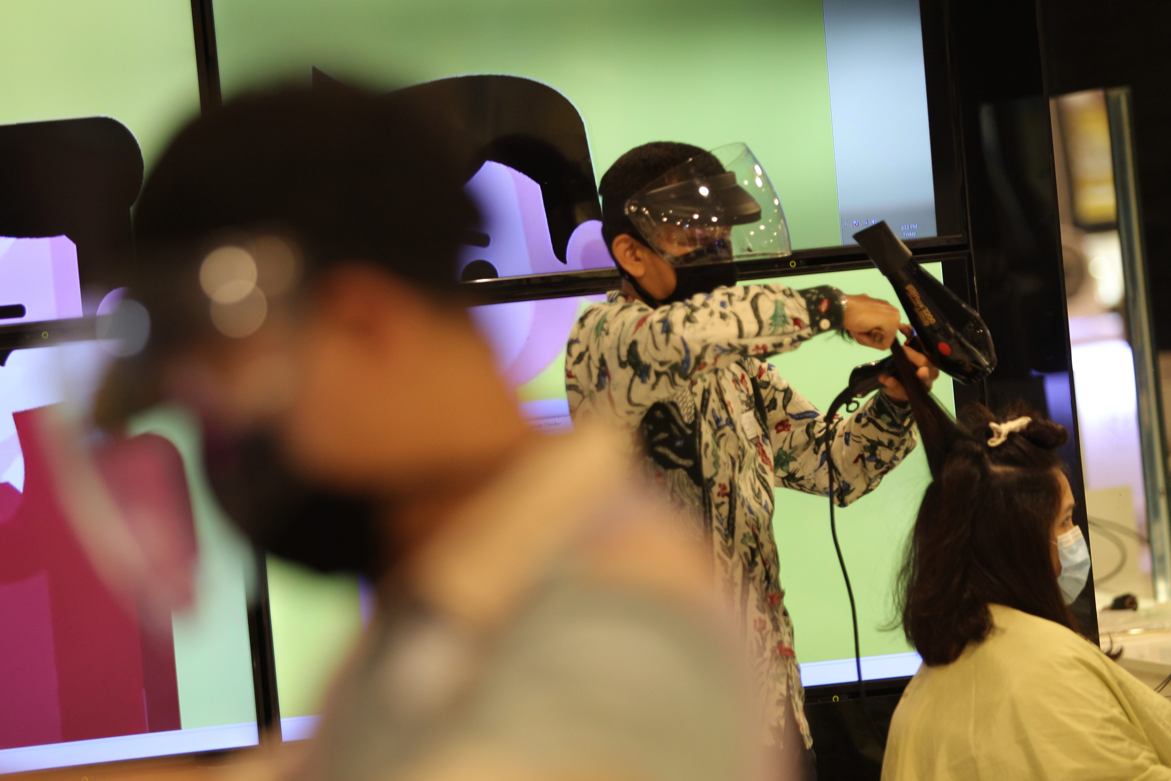 Pekerja salon menggunakan masker dan pelindung wajah di Jakarta, Jumat (26/6). 