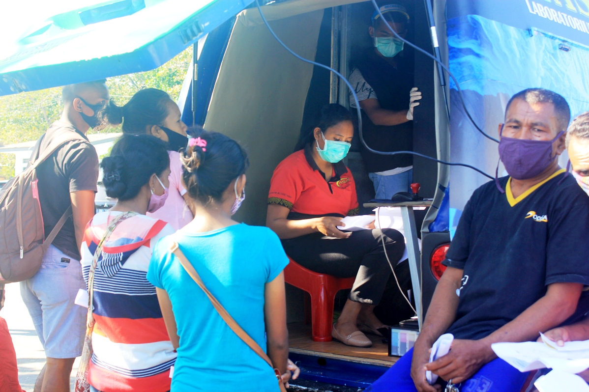 Sopir truk ekspedisi dan penumpang antre tanpa jaga jarak di mobil laboratorium di Pelabuhan Penyeberangan Kupang, NTT, Kamis (4/6). 