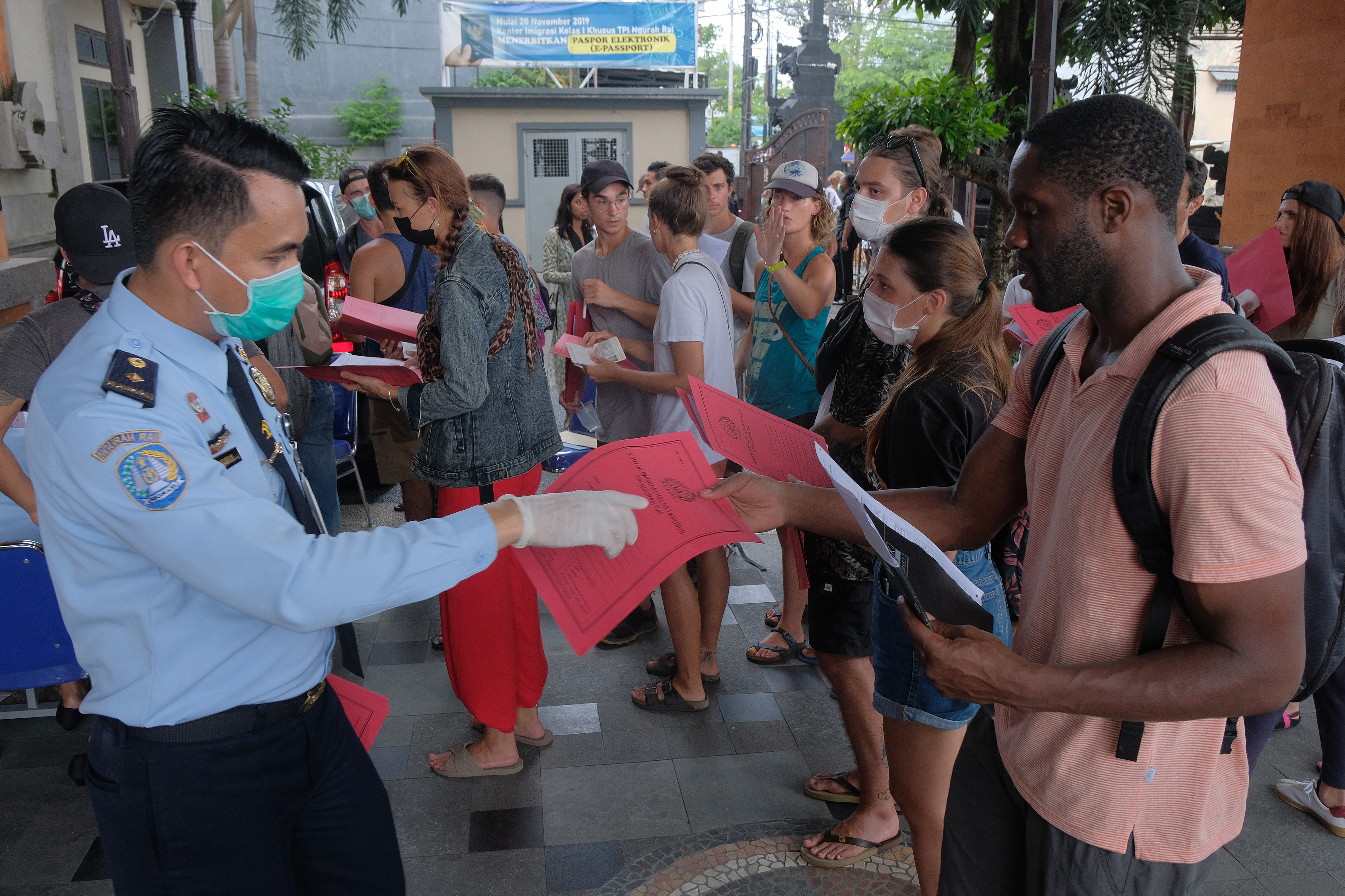 Petugas imigrasi memeriksa dokumen warga negara asing (WNA) saat mereka antre mengurus perpanjangan visa pada Maret 2020