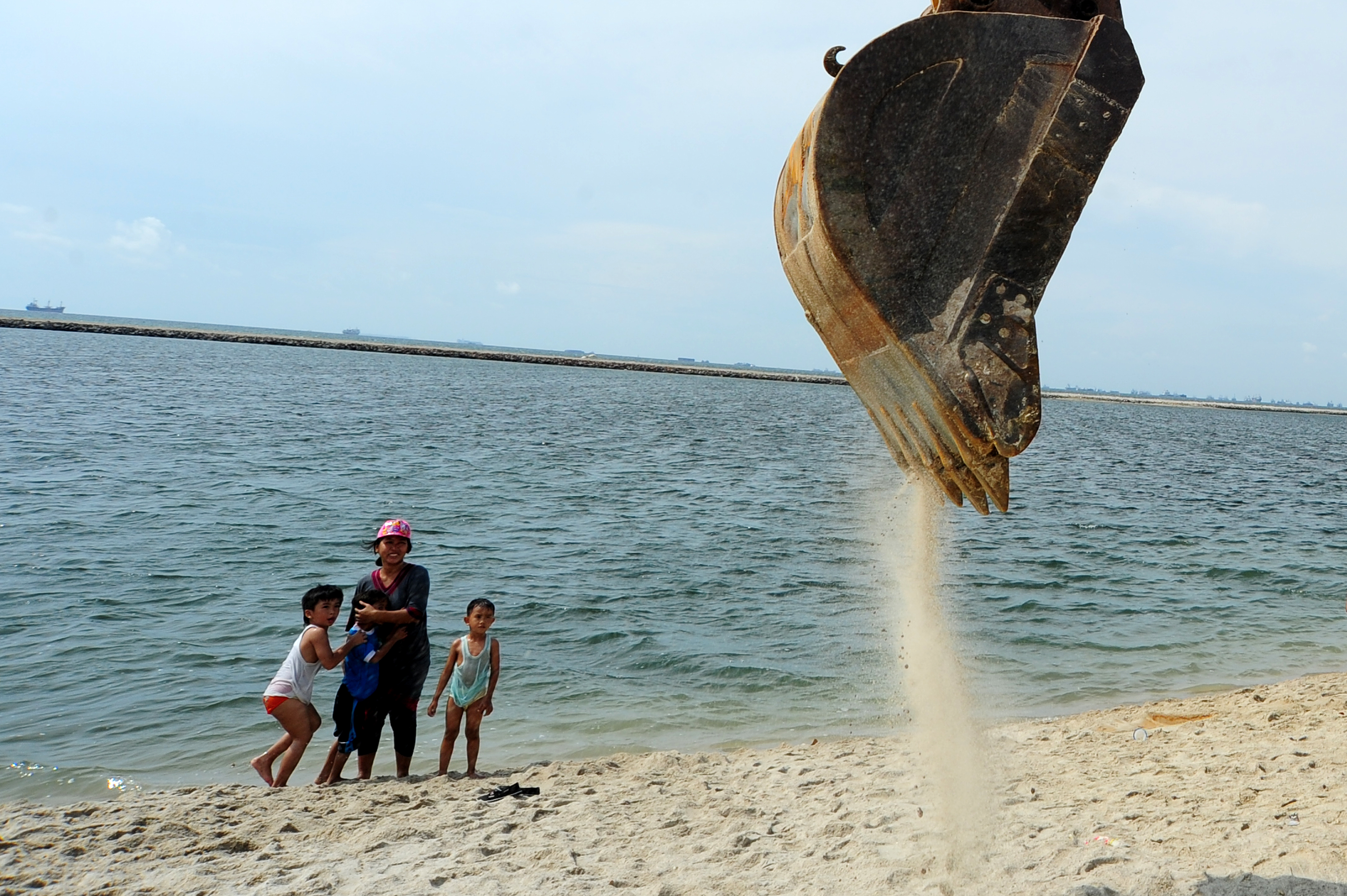 Sebuah ekskavator meratakan pasir di proyek reklamasi Pantai Ancol, Jakarta Utara