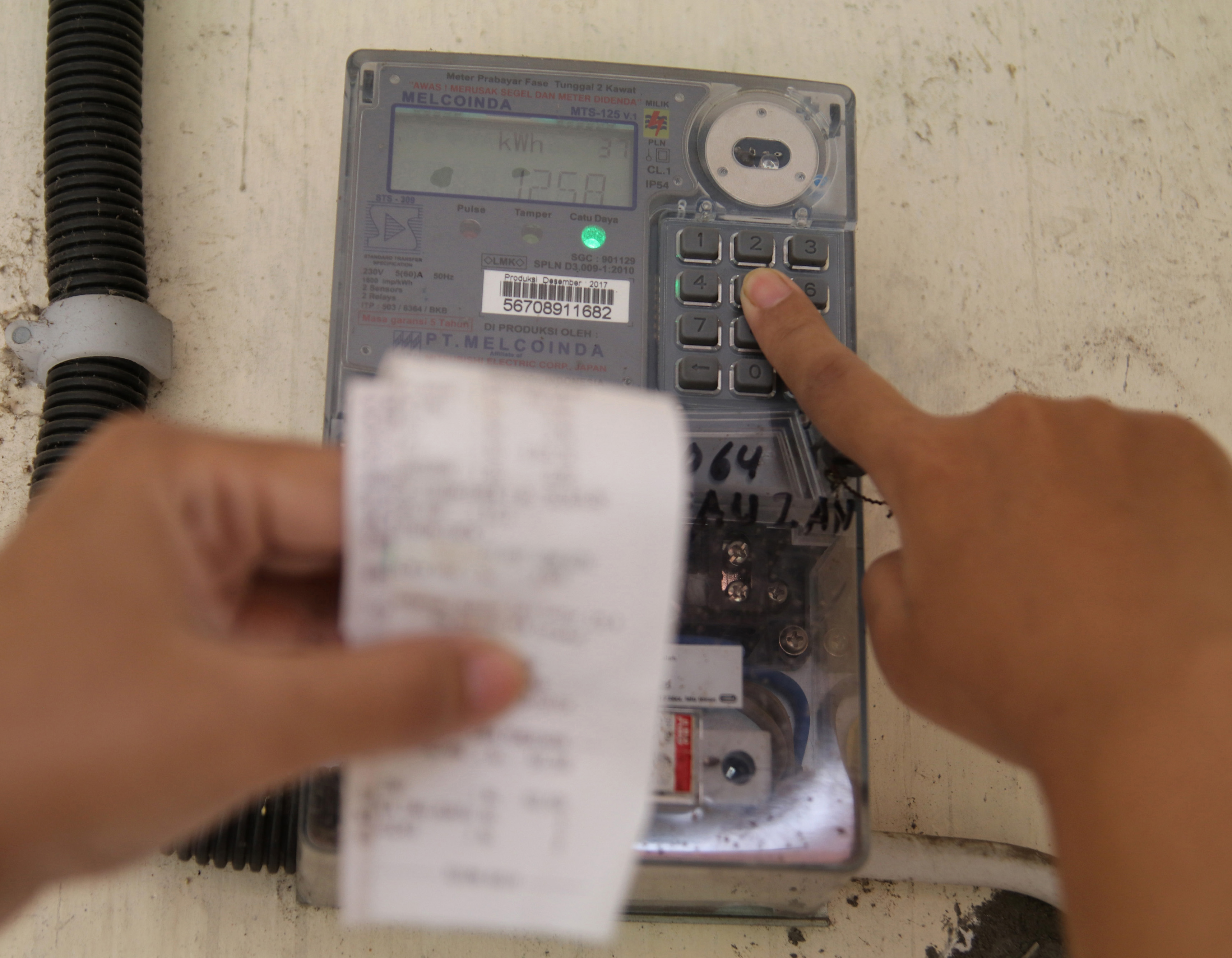 Warga memasukkan pulsa token listrik di rumahnya 