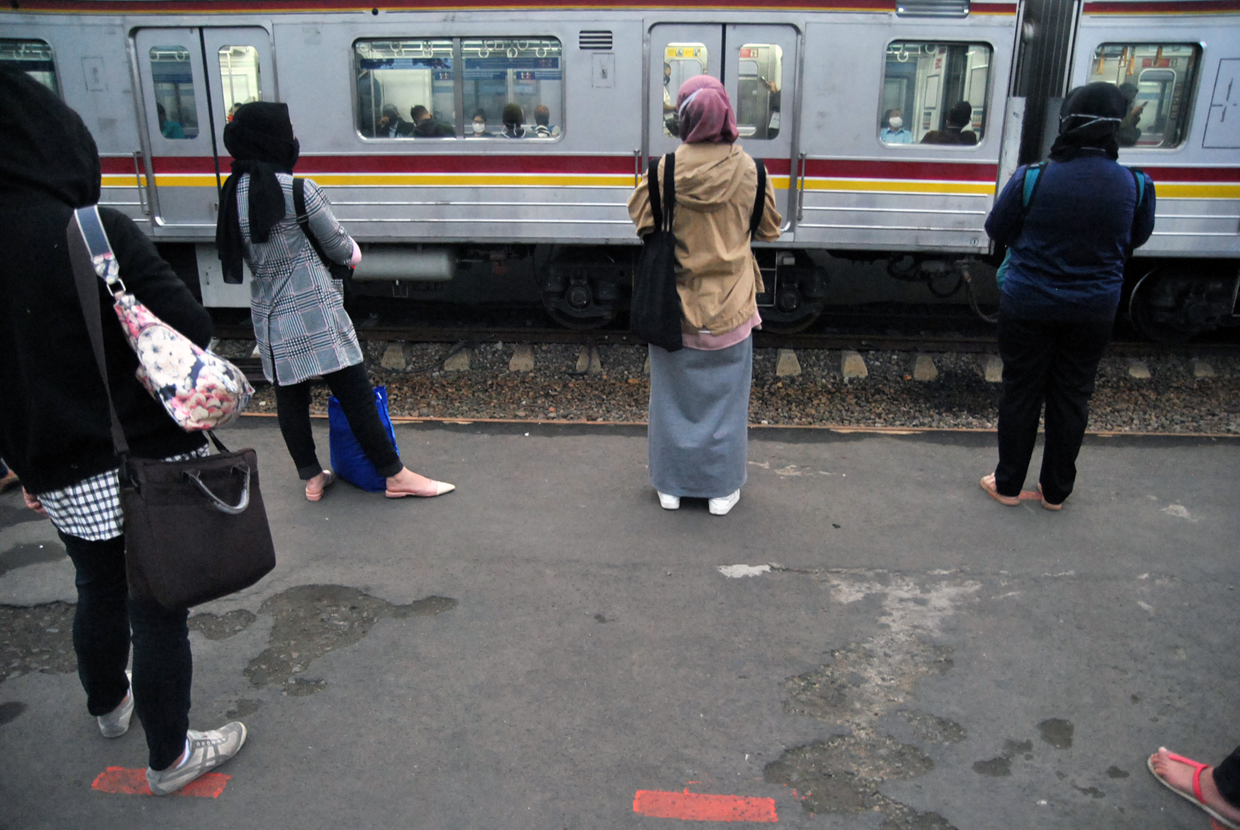  Sejumlah calon penumpang KRL Commuter Line menunggu kereta dengan berdiri sesuai tanda jarak fisik (physical distancing) di Stasiun Bogor.