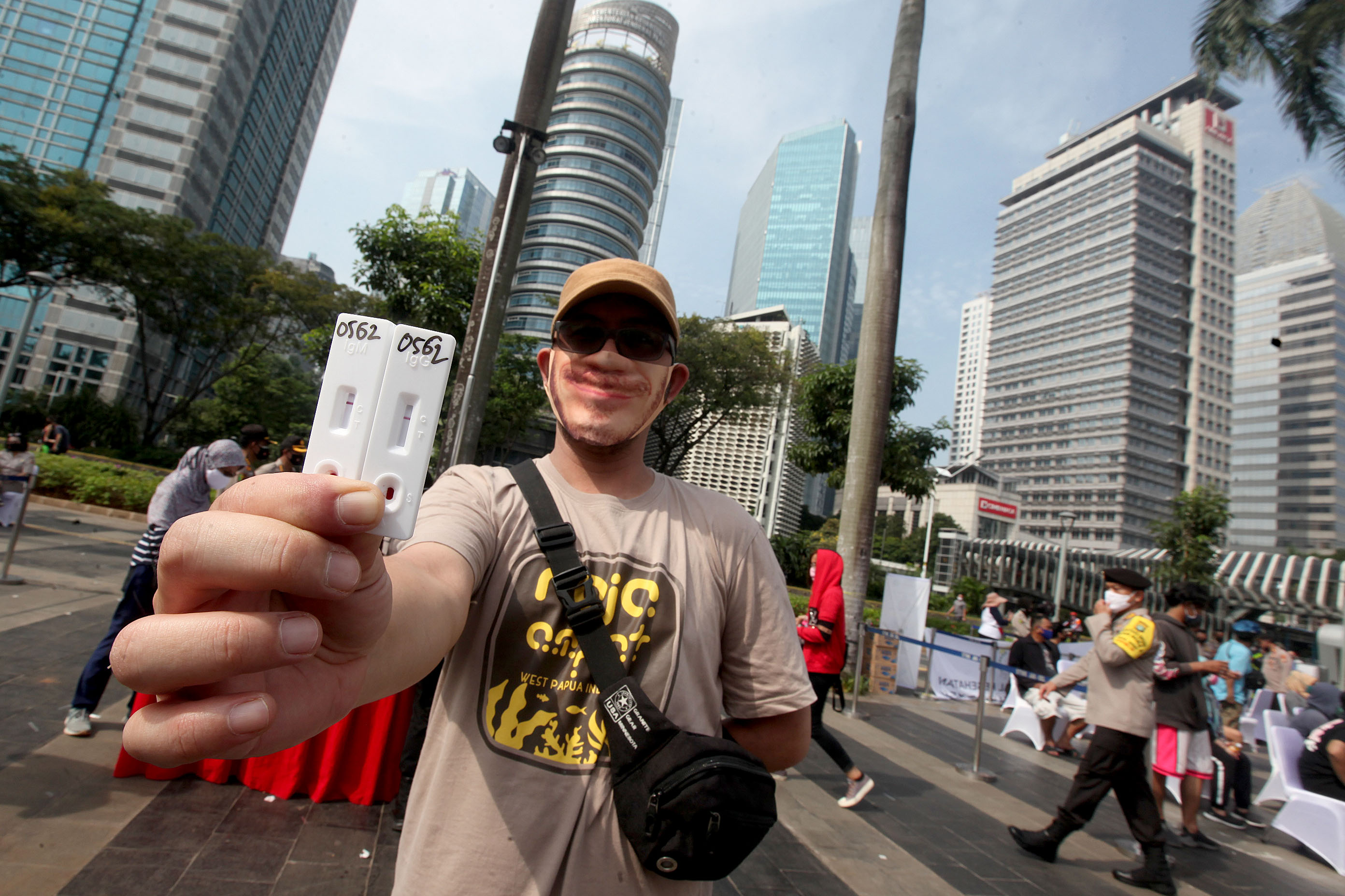Warga menunjukkan hasil rapid test covid-19 di Gelora Bung Karno, Jakarta Pusat, Minggu (21/6).