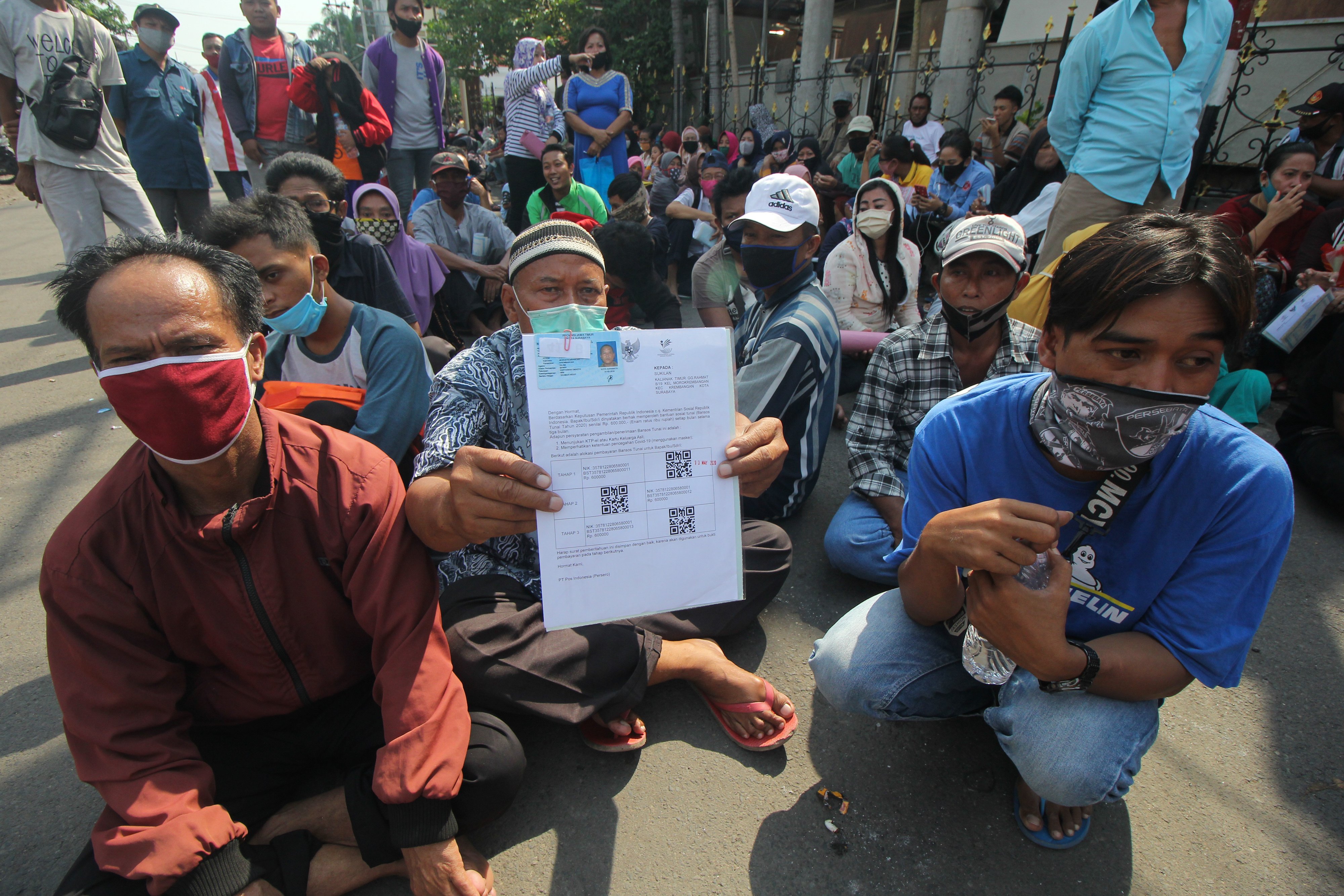 Warga antre untuk mengambil bantuan sosial tunai (BST) di Kantor Pos Kepanjen, Surabaya, Jawa Timur, Sabtu (6/6).