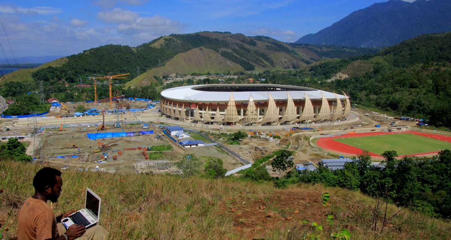 Warga menyaksikan proses pembangunan Kompleks Stadion Papua Bangkit di Distrik Sentani Timur, Kabupaten Jayapura, Papua, Jumat (15/3/2019).