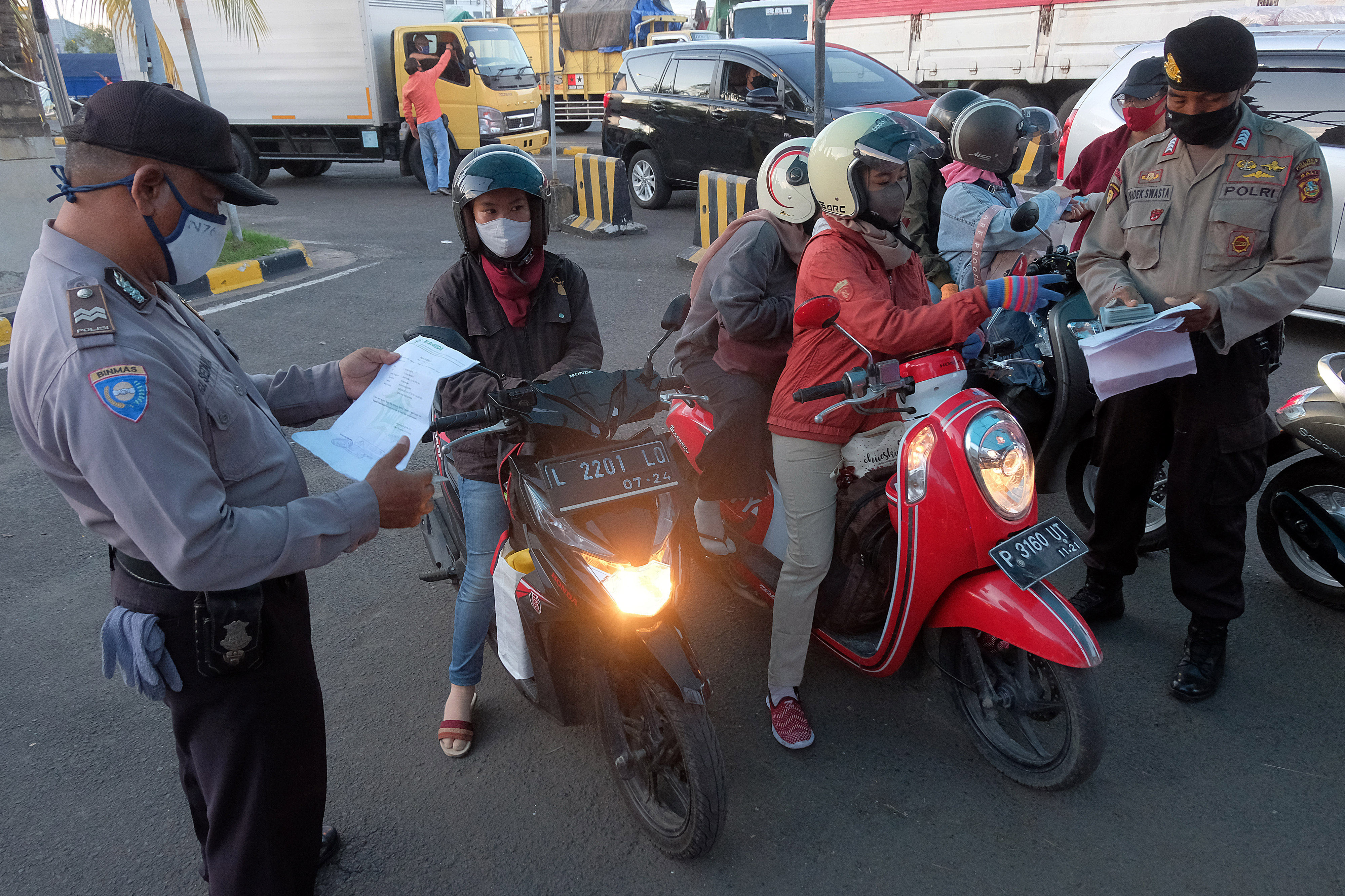 Polisi memeriksa kelengkapan surat pemudik yang datang dari pulau Jawa setibanya mereka di Pelabuhan Gilimanuk, Jembrana