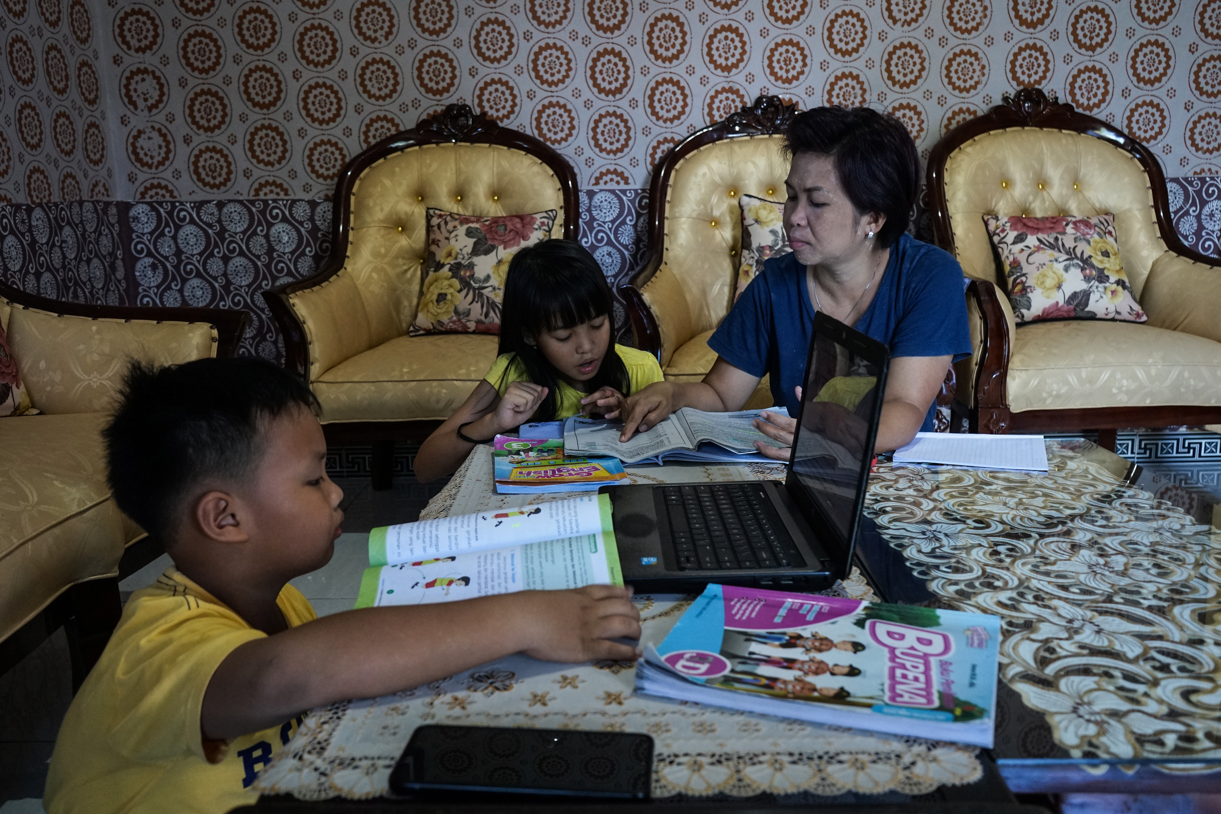 Siswa mengerjakan tugas didampingi ibunya dirumahnya, di Palangkaraya, Kalimantan Tengah, Selasa (14/4/2020).