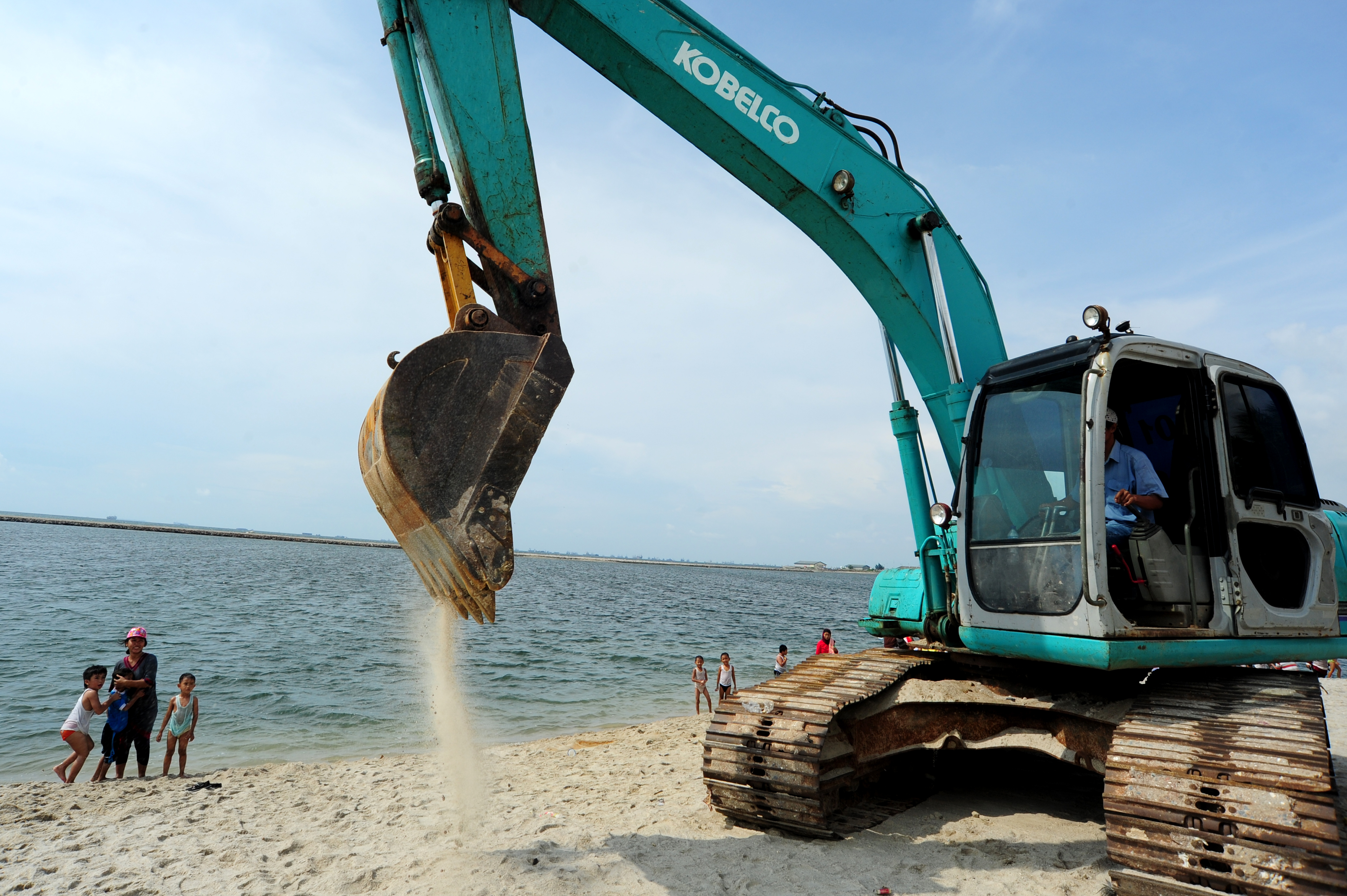 Sebuah ekskavator meratakan pasir di proyek reklamasi Pantai Ancol, Jakarta Utara