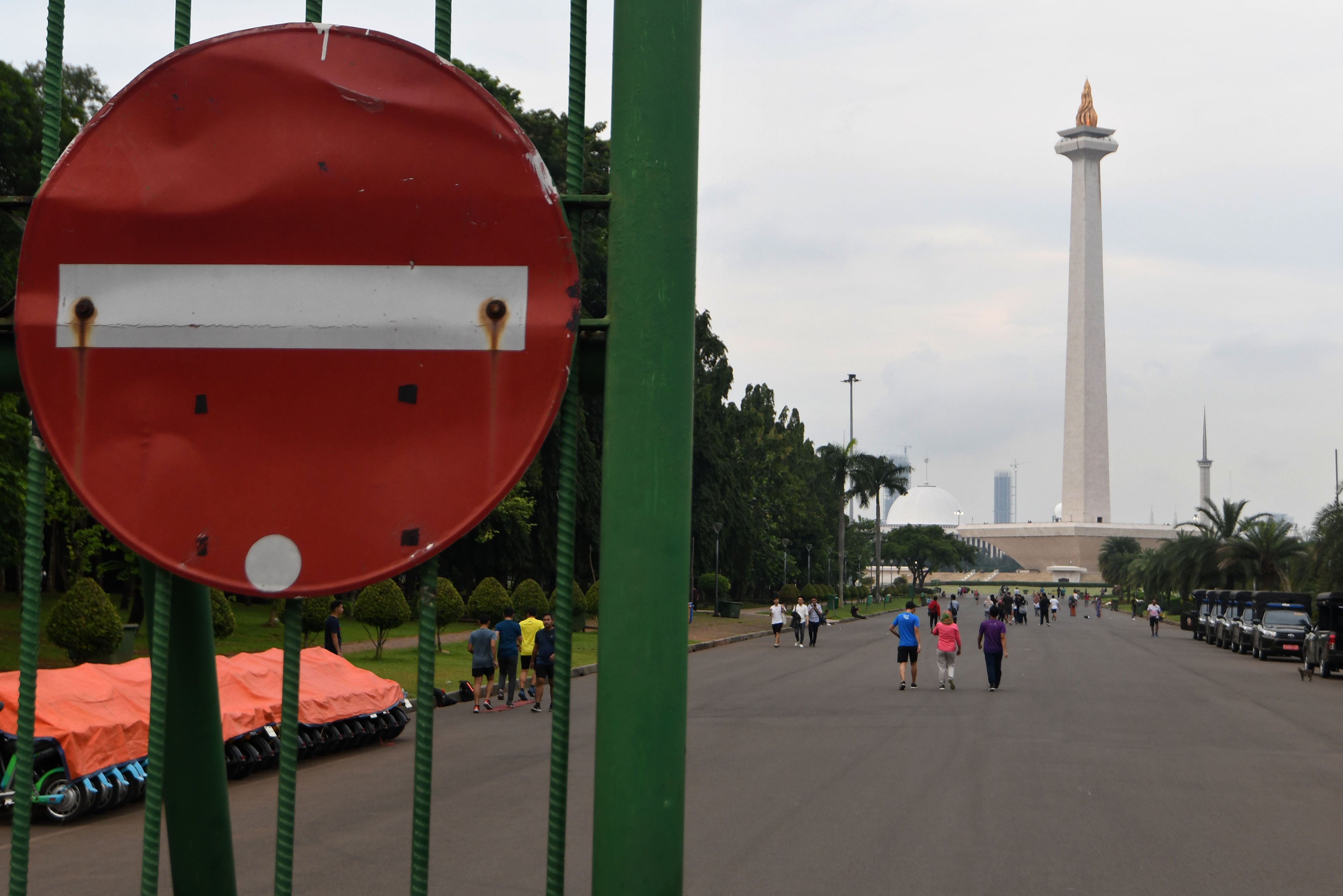 Warga berjalan di kawasan Monumen Nasional, Jakarta.
