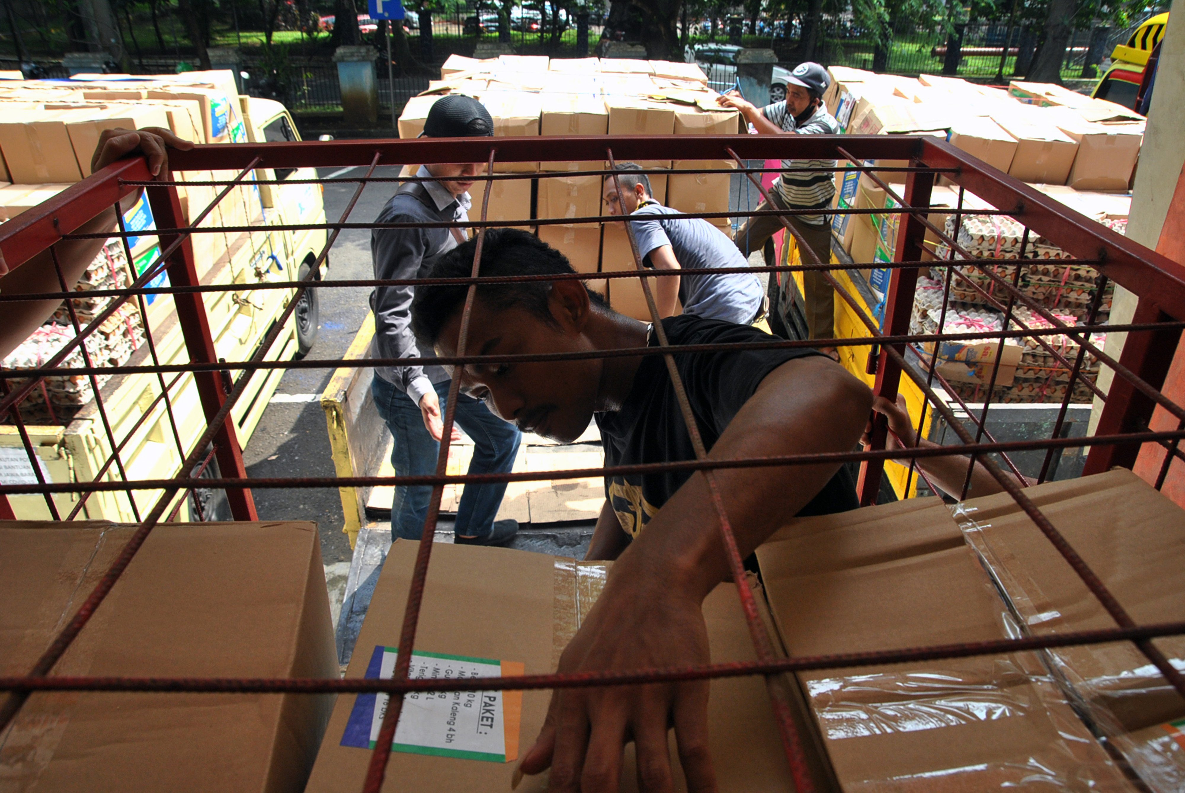 Pekerja menurunkan bantuan sosial untuk warga akibat pandemi covid-19