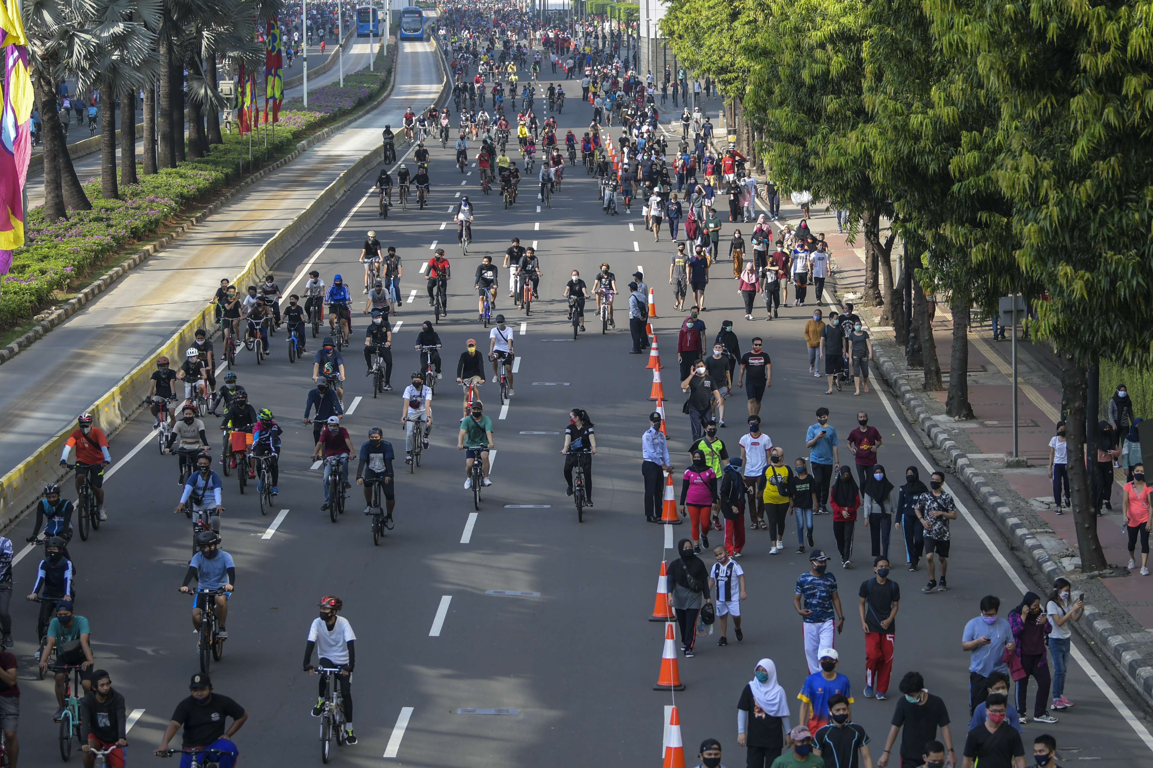 Warga berolahraga saat hari bebas berkendara atau Car Free Day (CFD) di kawasan Jalan M.H. Thamrin, Jakarta, Minggu (21/6/2020).