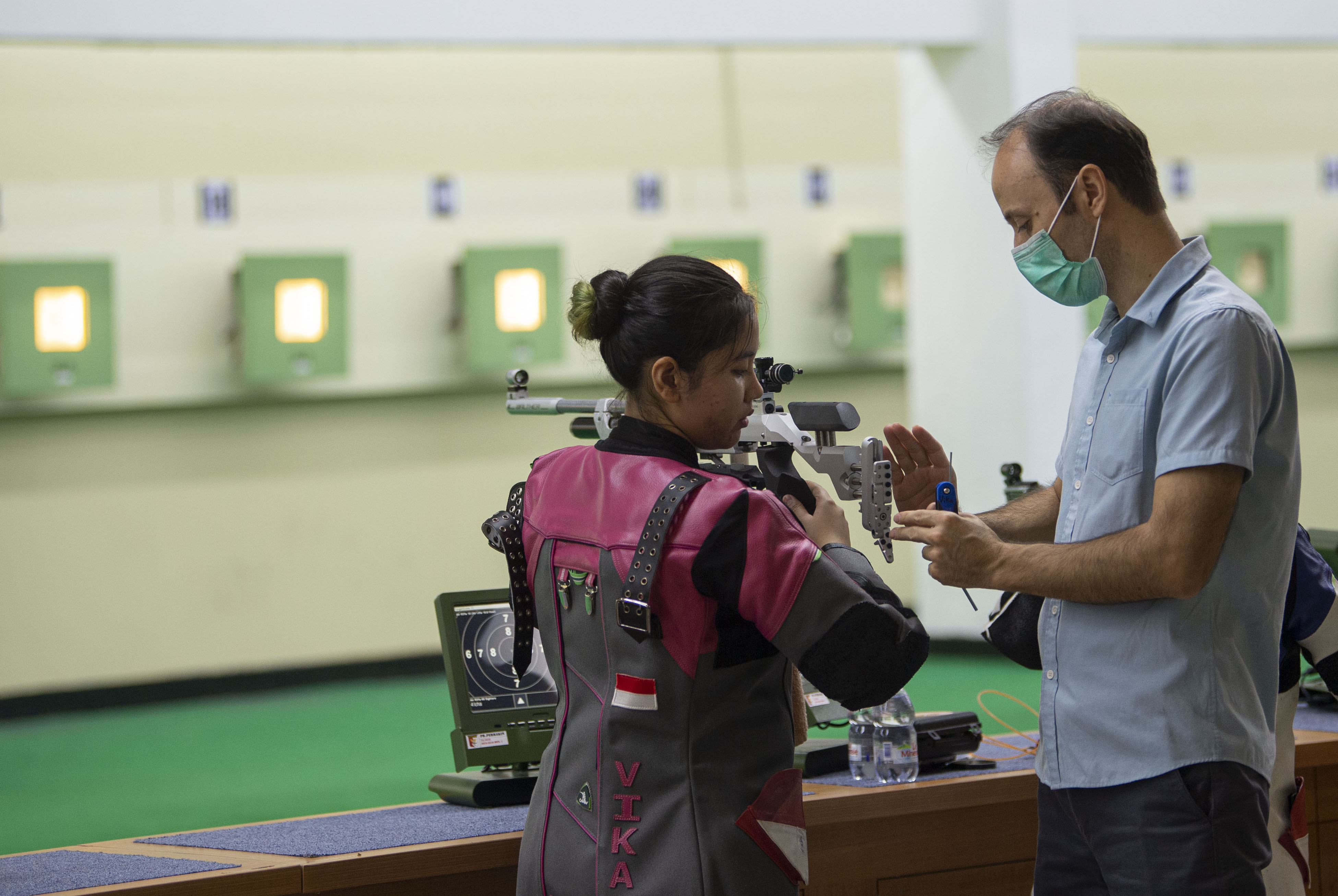 Vidya Rafika Rahmatan mendengarkan instruksi pelatih Ebrahim Inanloy saat berlatih di Lapangan Tembak Senayan, Jakarta, Jumat (12/6).