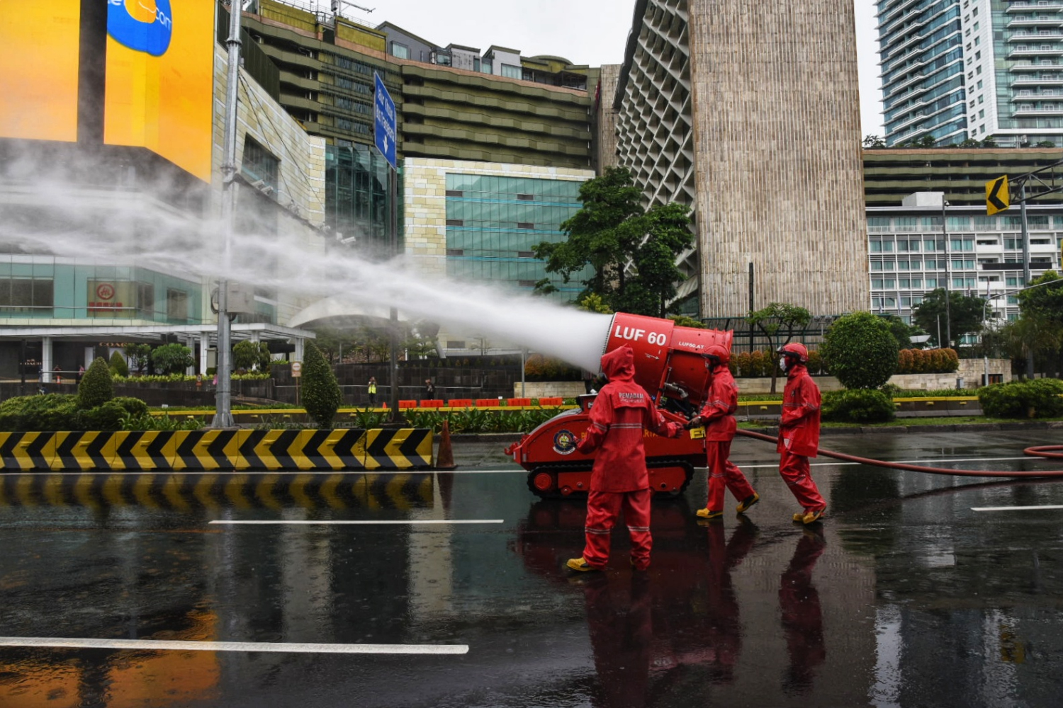 Petugas Dinas Penanggulangan Kebakaran dan Penyelamatan Provinsi DKI Jakarta sedang menyemprtkan disinfektan di Bundaran HI