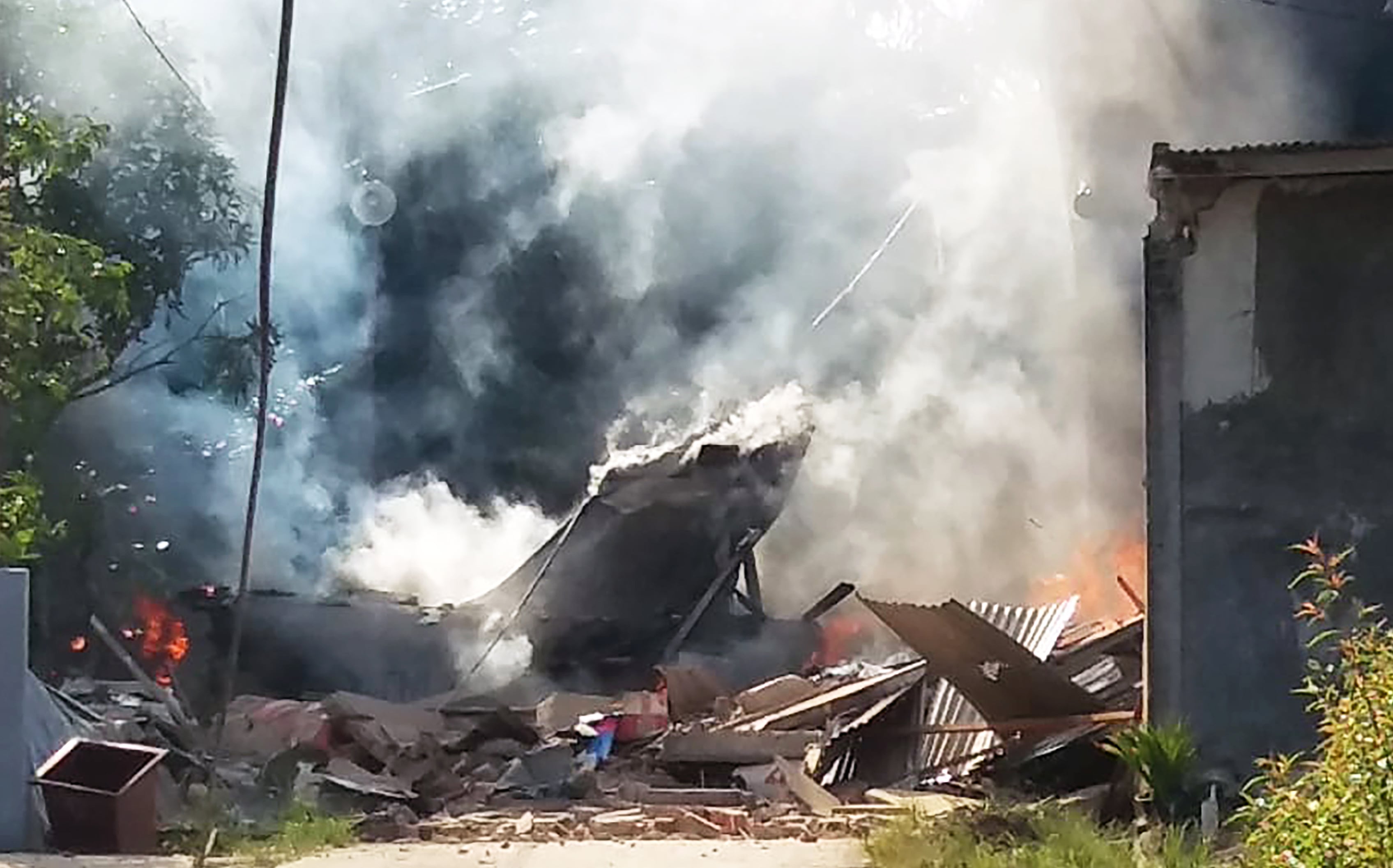 Asap membubung dari pesawat milik TNI AU yang jatuh dan terbakar di daerah permukiman penduduk di Desa Kubang Jaya Kecamatan Siak Hulu.