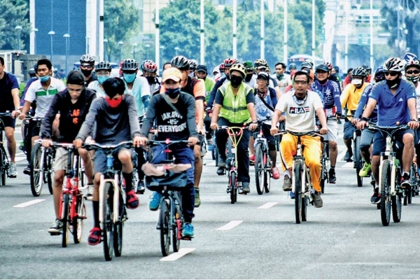 Warga beramai-ramai bersepeda melintas pada pukul 07.30 WIB di kawasan Jalan MH Thamrin, Jakarta, kemarin.