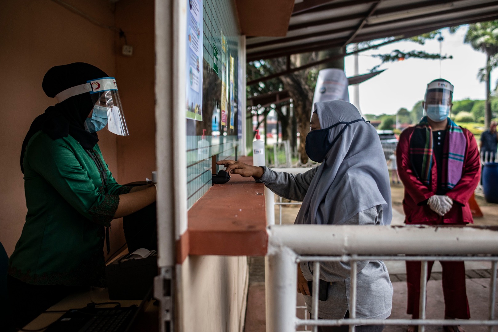 Petugas melayani wisatawan membeli tiket masuk saat berlangsungnya simulasi normal baru di TMII, Jakarta