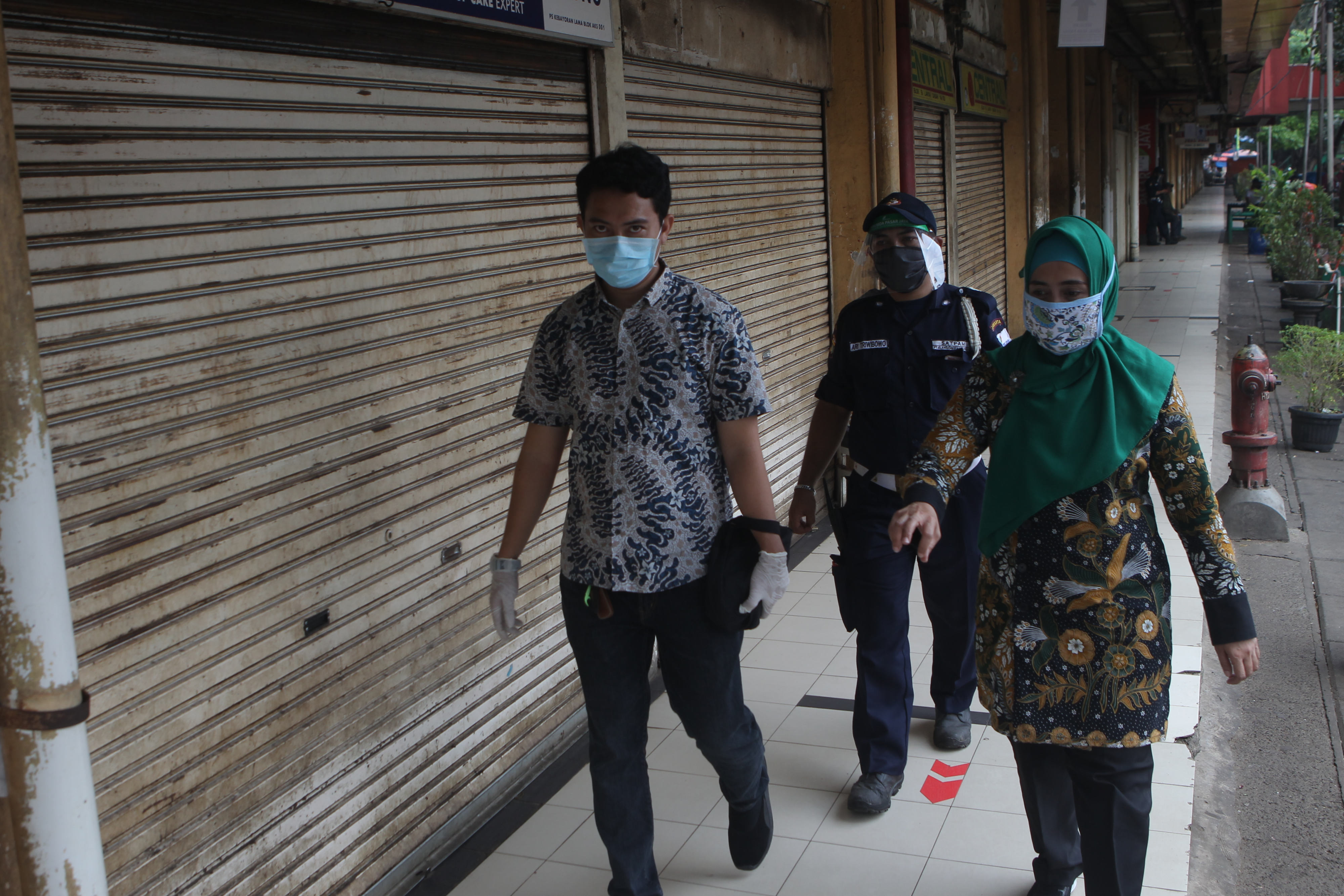 Petugas melakukan penjagaan di depan kios-kios pedagang yang tutup di Pasar Kebayoran Lama, Jakarta Selatan, Jakarta, Kamis (18/6). 