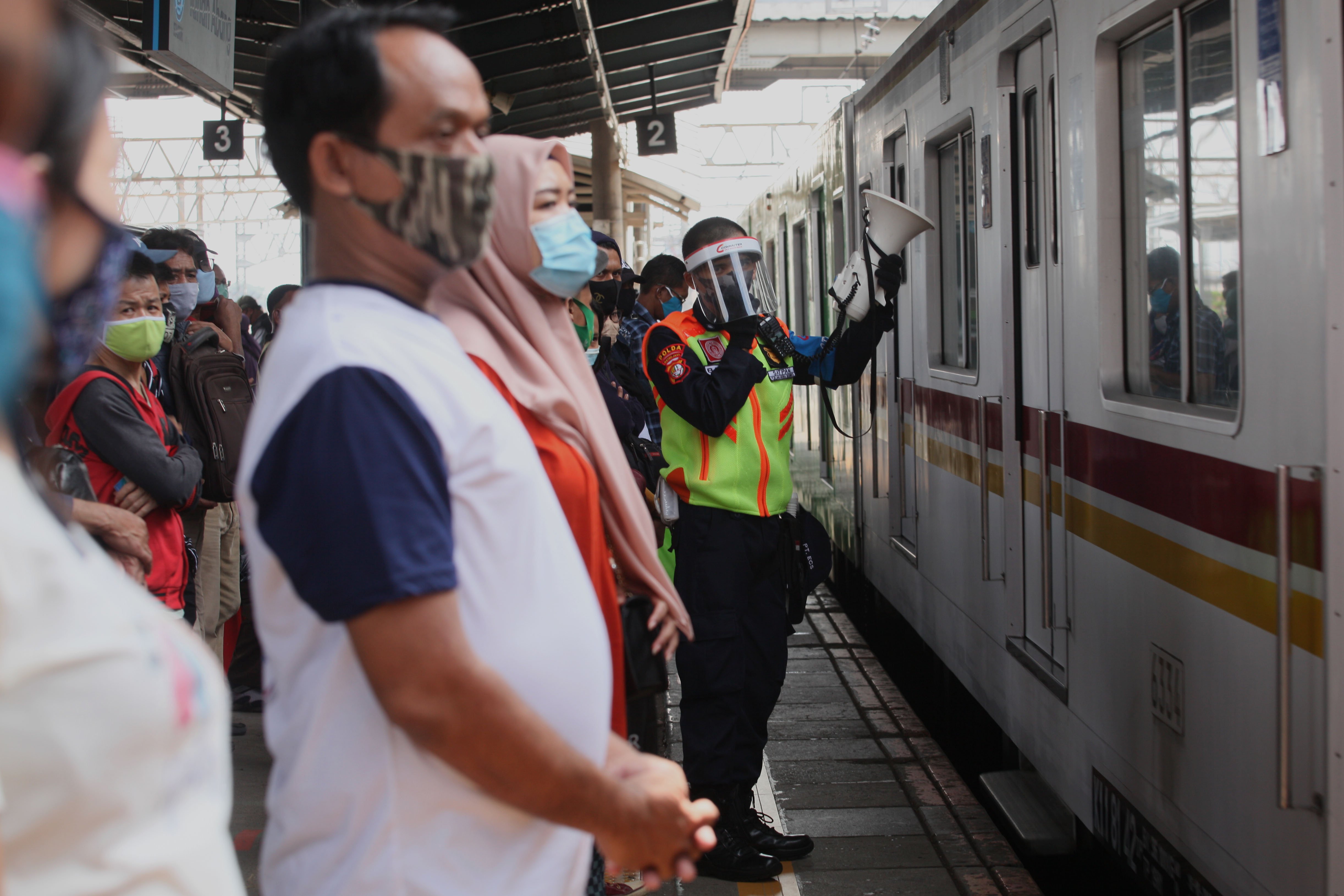 Petugas memberikan imbauan pendisiplinan protokol kesehatan pencegahan COVID-19 kepada penumpang KRL di Stasiun Tanah Abang