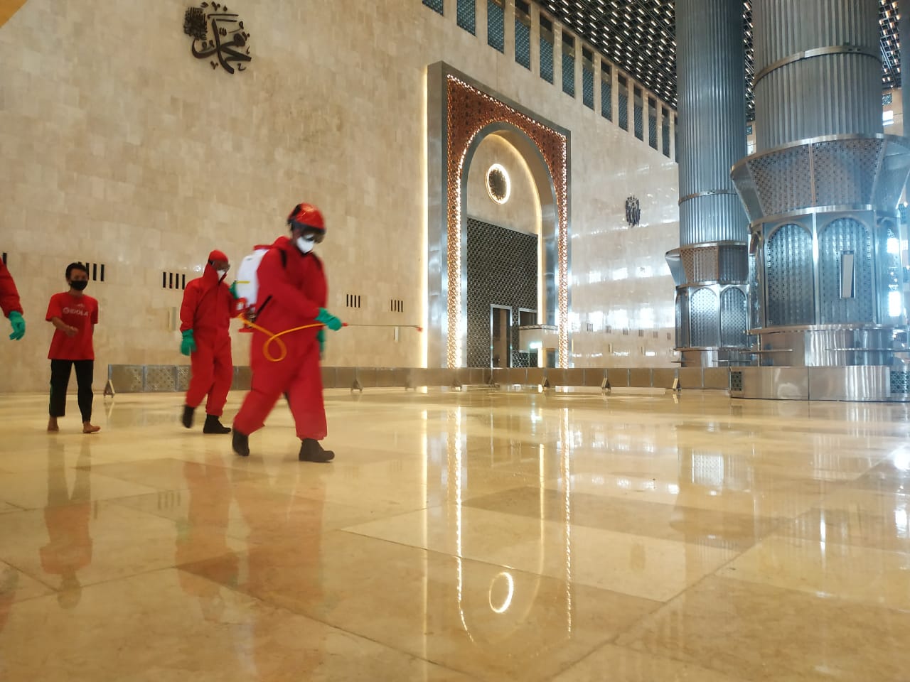  Petugas gabungan dari Dinas Penanggulangan Kebakaran dan Penyelamatan DKI Jakarta menyemprot disinfektan di Istiqlal