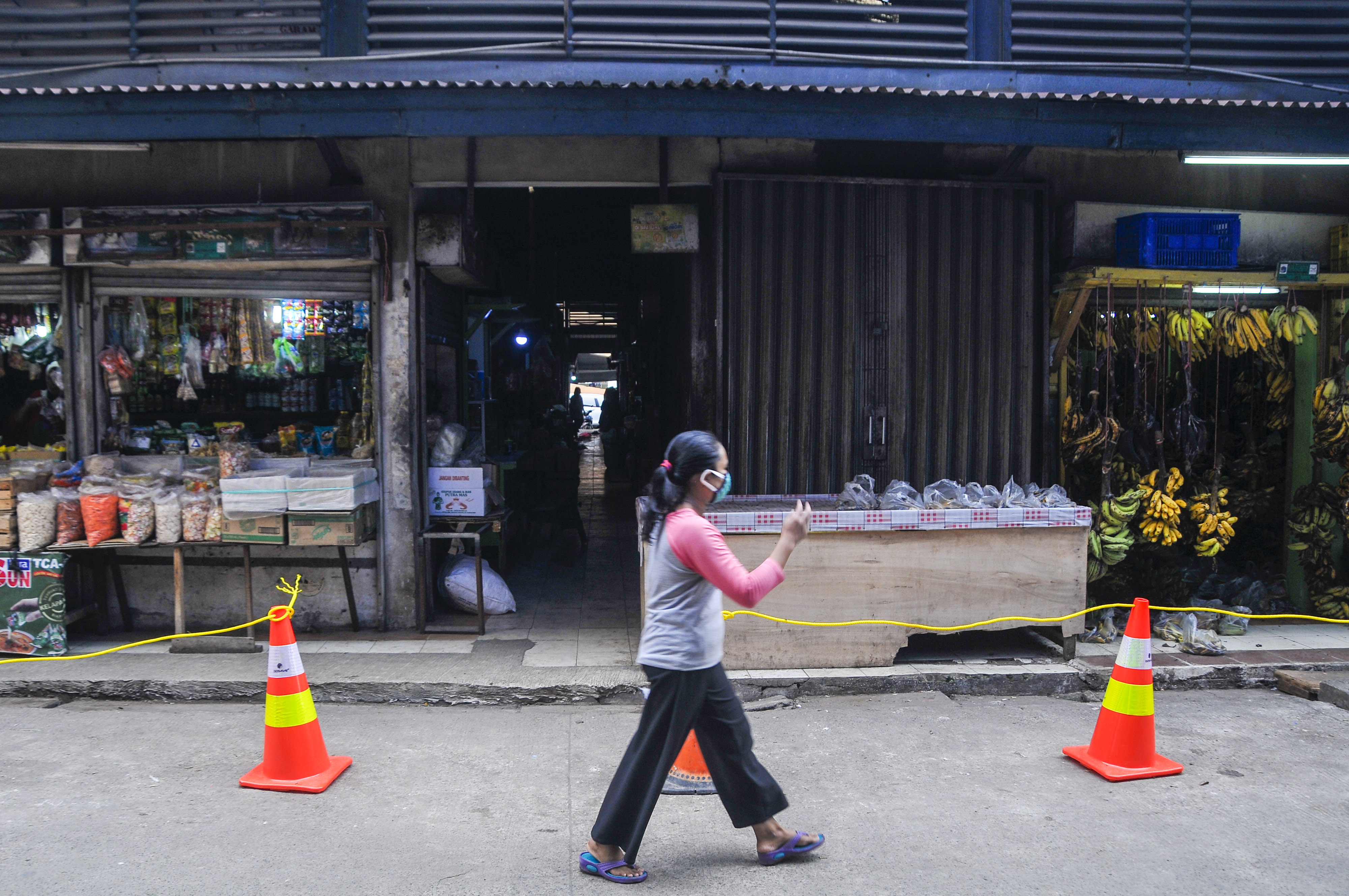 Warga melintas di Pasar Perumnas Klender, Jakarta Timur, Senin (15/6).