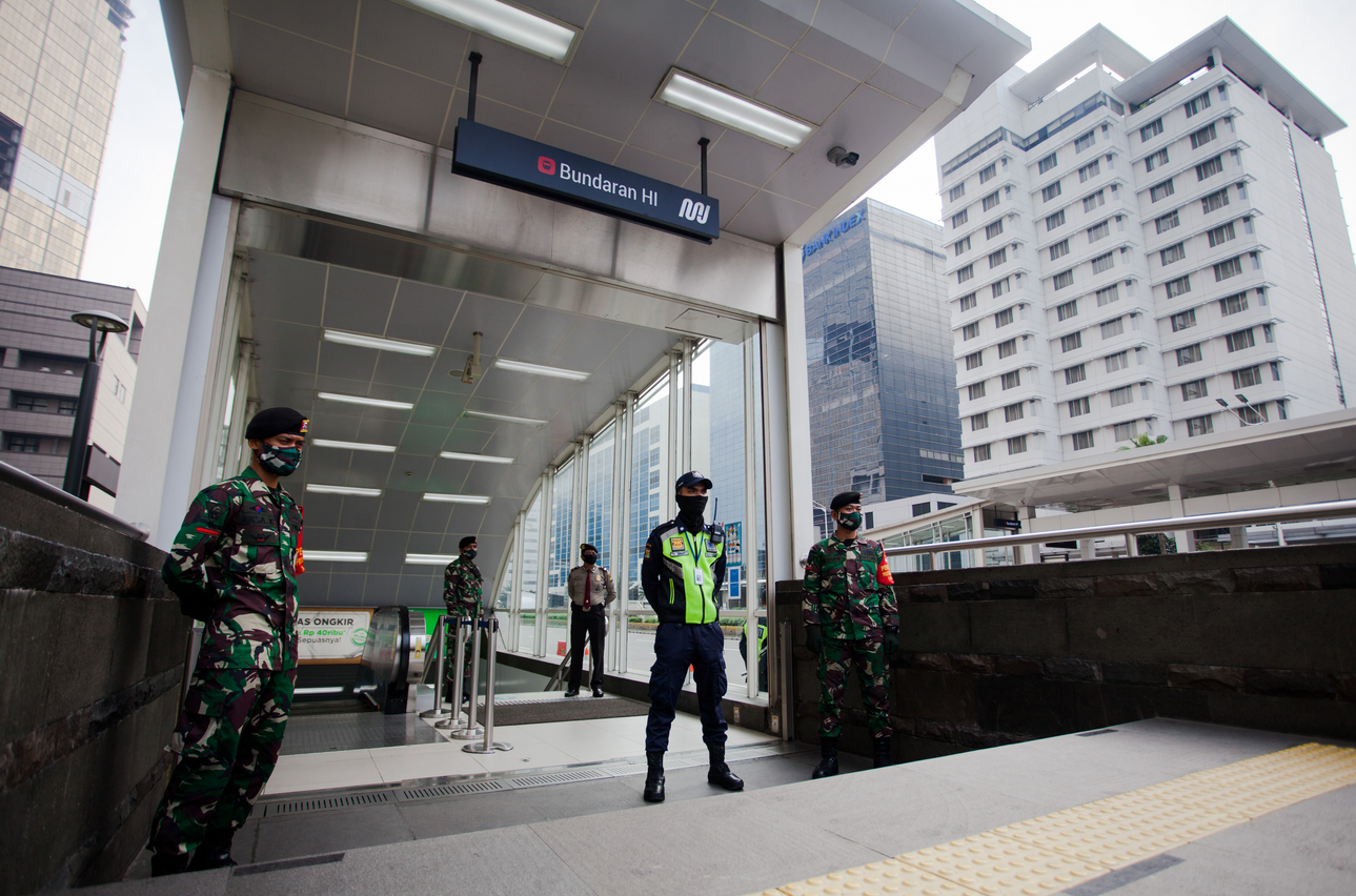 Satgas Pengawas Protokol Covid-19 TNI-Polri berjaga di pintu MRT Bundaran HI, Jakarta, Selasa (5/6). 